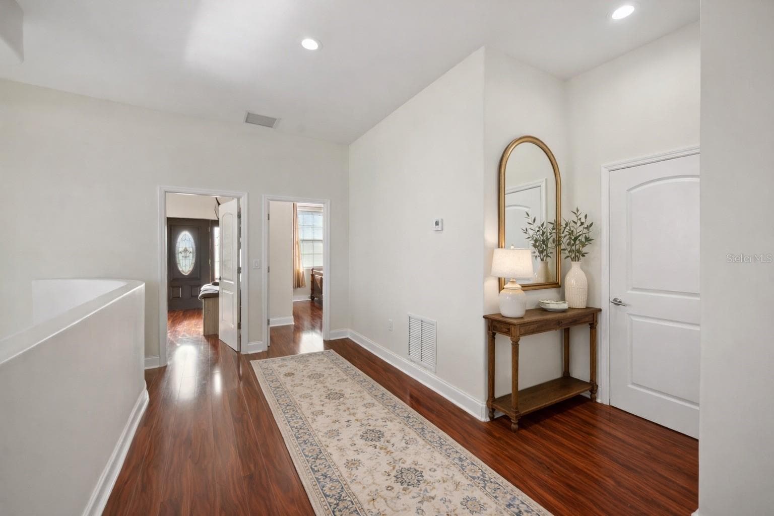 Upstairs hall area, door to the right is access to upstairs laundry - Virtual staging added to demonstrate possible furniture placement. - 775 CHRISTINA LAKE DR, LAKELAND