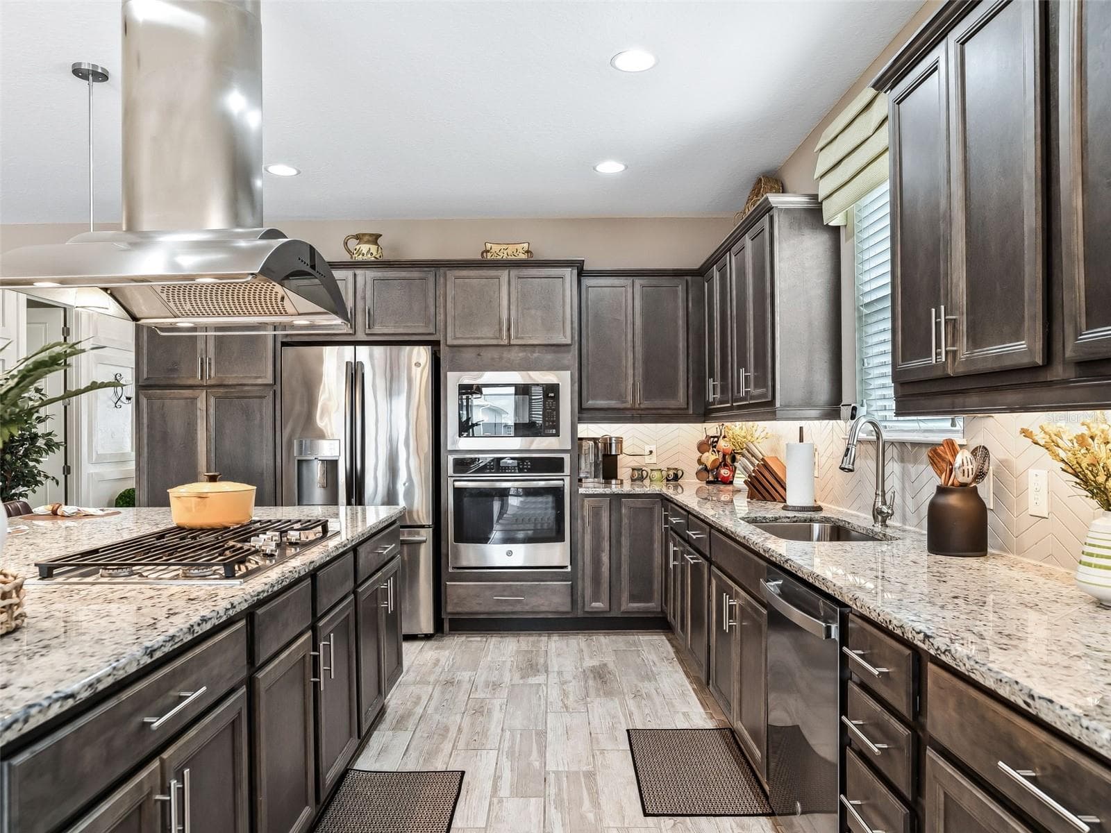 Gourmet Kitchen built-in oven and microwave, 36" gas cooktop, stainless steel chimney hood with tons of storage. - 5662 NW 40TH LOOP, OCALA