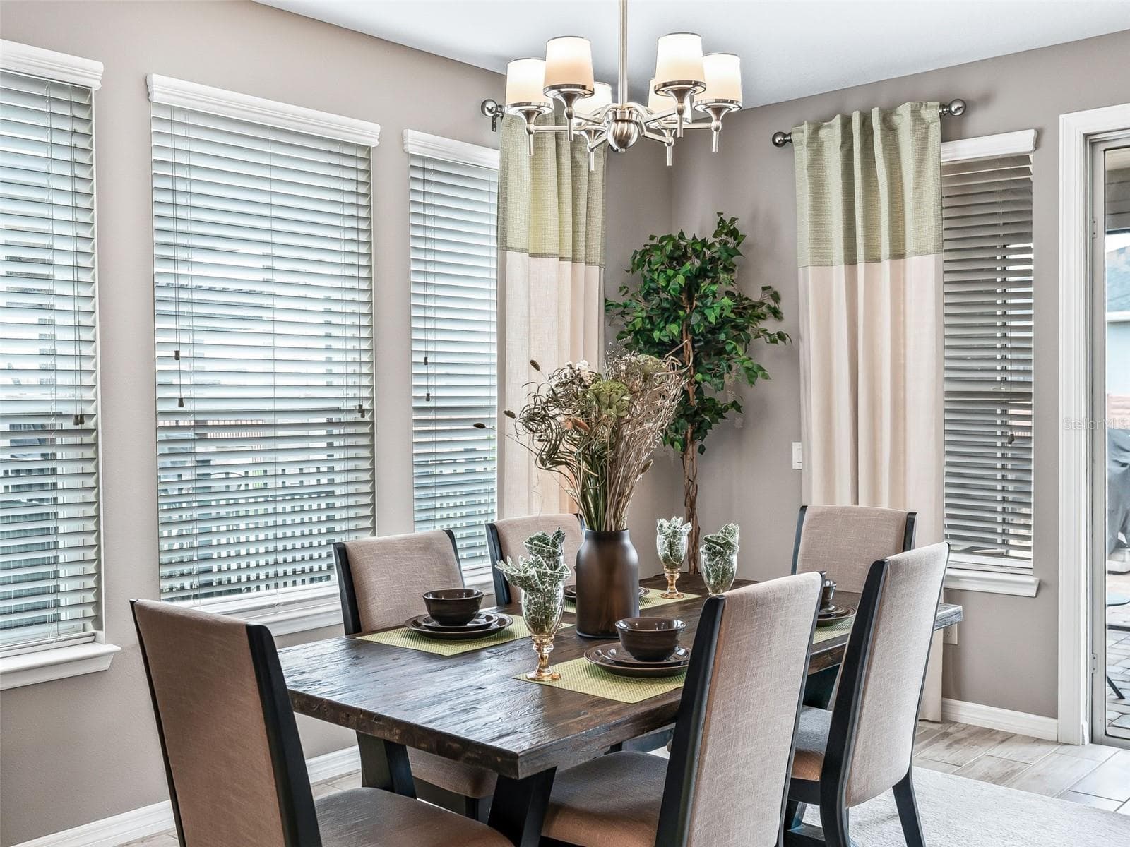 Formal dining space with chandelier, plenty of windows allowing the natural lighting into the home - 5662 NW 40TH LOOP, OCALA