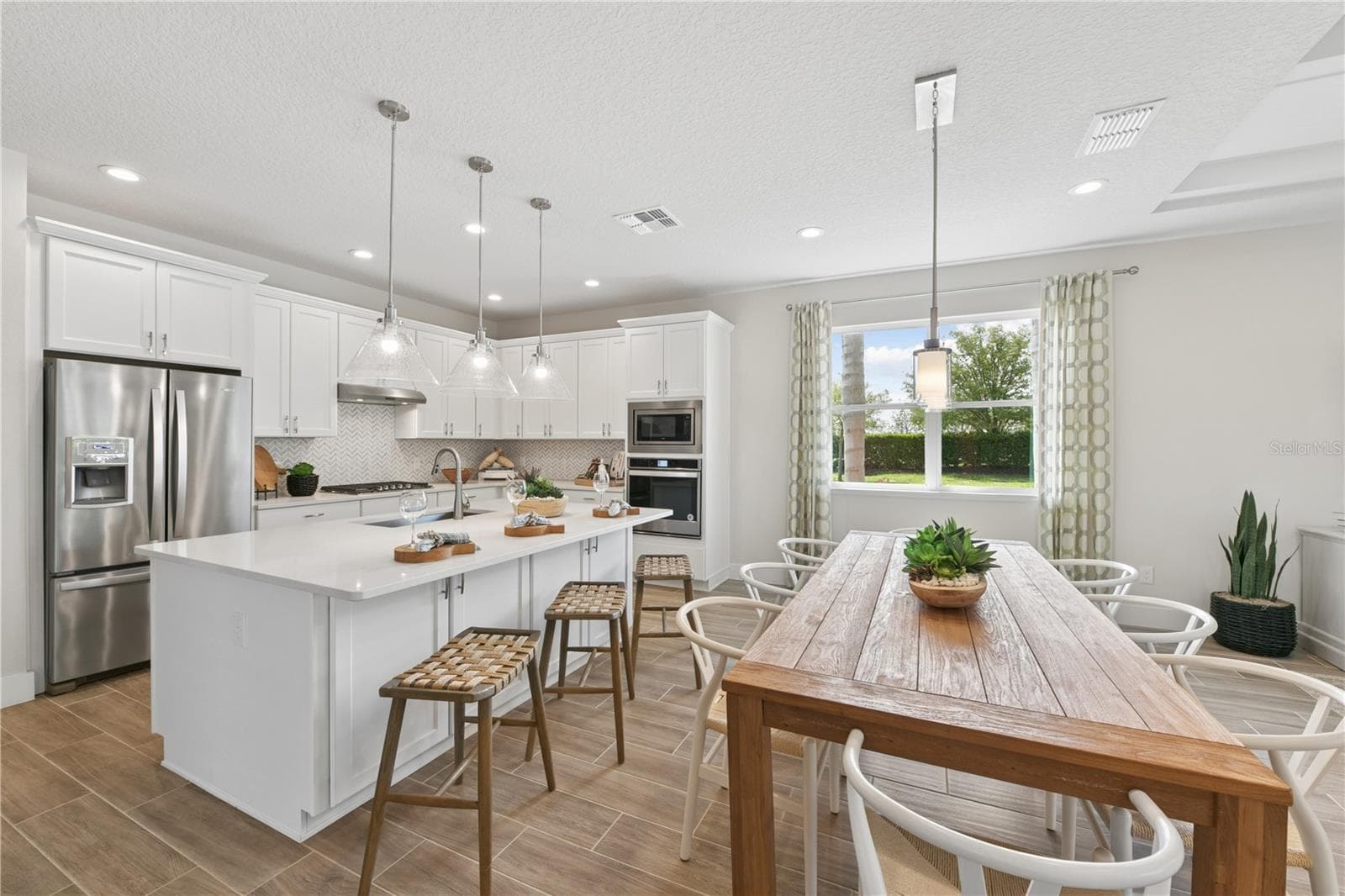 Bright gourmet kitchen with crisp finishes, light cabinetry, and natural textures for an effortless, airy feel. - 2418 PARK RIDGE ST, APOPKA