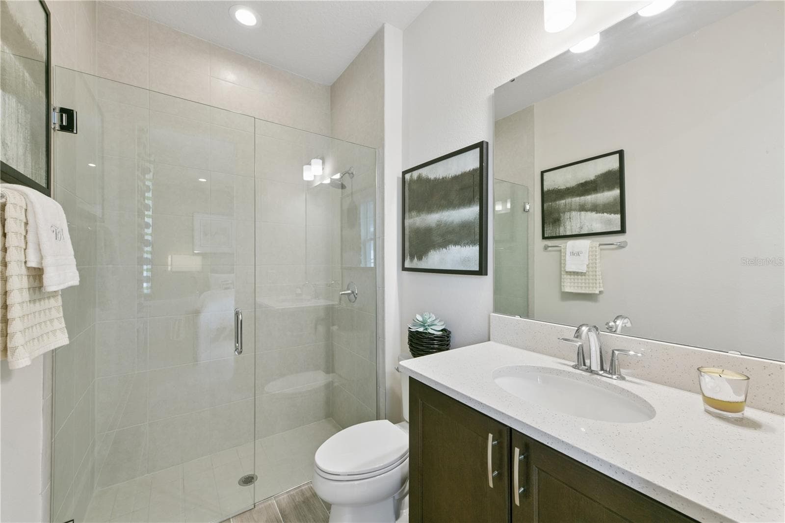 Private ensuite retreat with a spacious walk-in closet and a sleek walk-in shower in soothing finishes. - 2418 PARK RIDGE ST, APOPKA