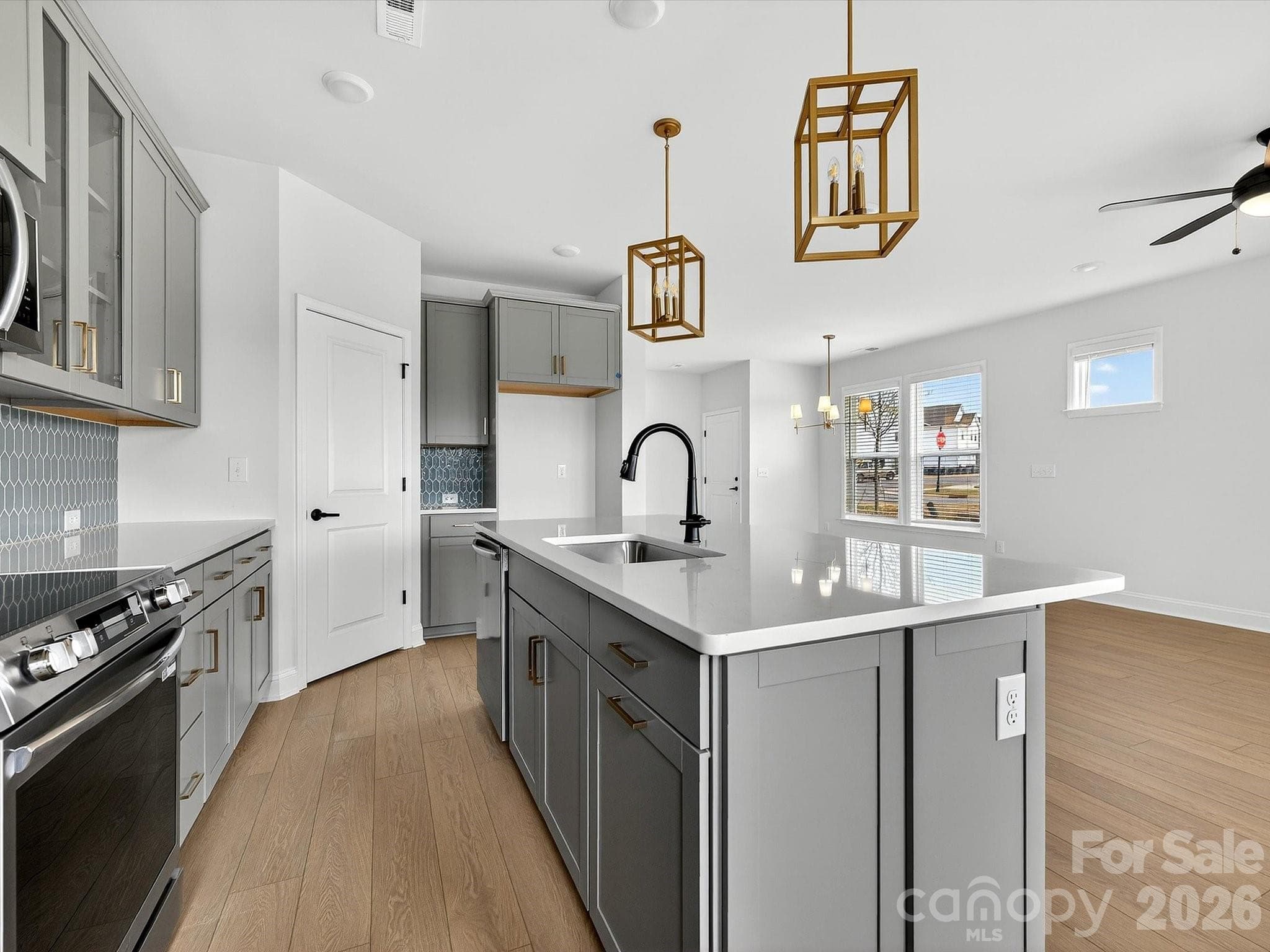 42" cabinets with soft close doors and drawers, quartz countertops, tile backsplash. Frigidaire gallery appliances. Microwave is exhaust vented to the outside. Large pantry with solid shelving - 218 Quartz Hill Way, Waxhaw