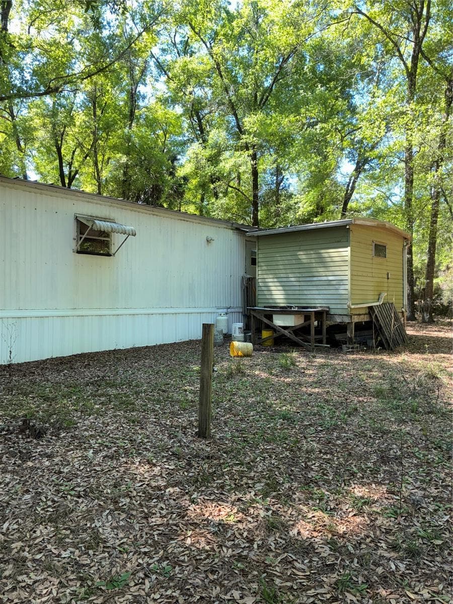 Rear or home. Shed just off of the back door houses the washer and dryer and a workbench. With some room for additional storage. - 24533 PINK PANTHER RD, PAISLEY
