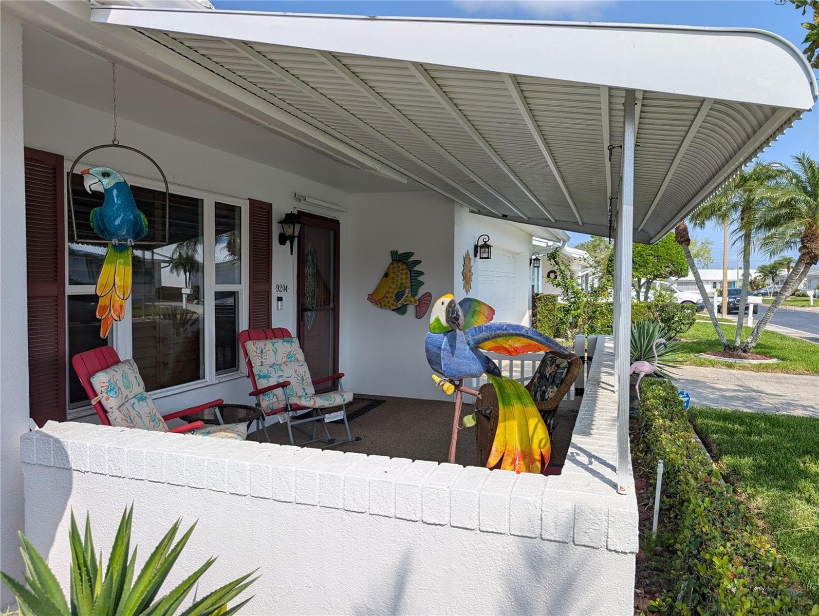 View of covered front porch with pebble tek flooring.  Great place to enjoy the Florida outdoor lifestyle. Main entry has new matching front & storm door including storm protection panels. COME ON IN... LET'S TAKE A TOUR! - 9204 36TH WAY N #6, PINELLAS PARK