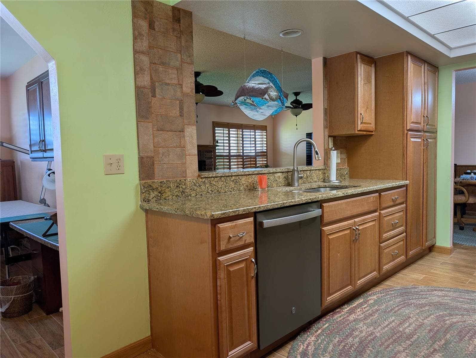 View from dinette area into Bonus room (left), Florida room (in pass thru window) and dining room at end of kitchen. Better view of gorgeous rustic tile backsplash. - 9204 36TH WAY N #6, PINELLAS PARK