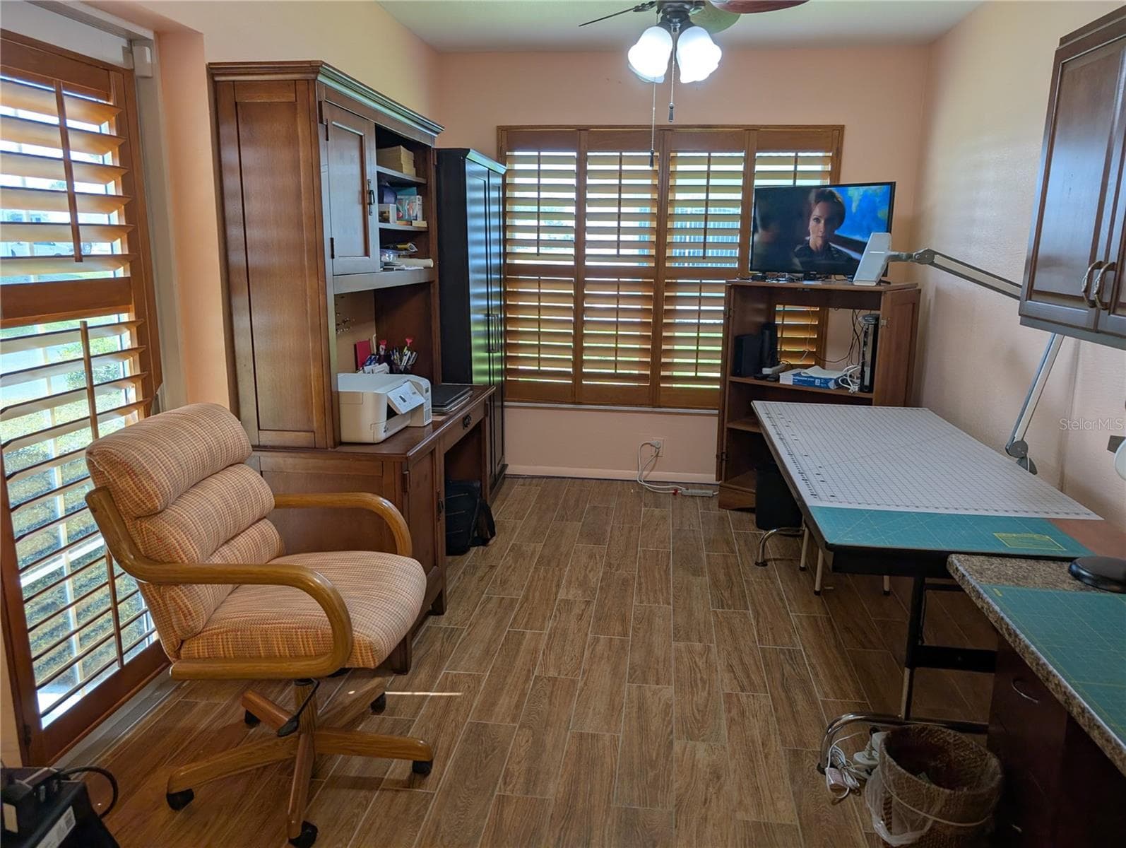 Bonus room is currently used as office and craft room.  Same decor is carried throughout the interior.  Side exterior door is lower left behind chair. - 9204 36TH WAY N #6, PINELLAS PARK
