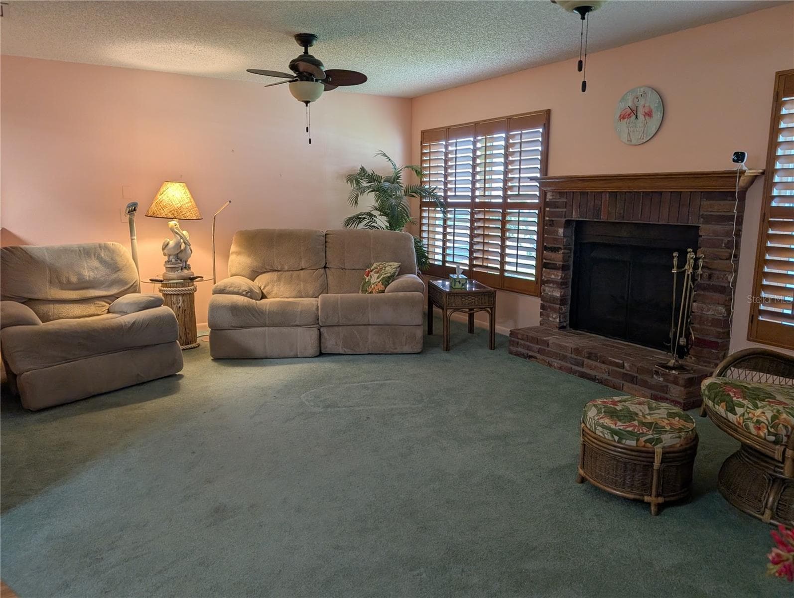 Carpeted Florida room has two windows framing the wood burning fireplace. - 9204 36TH WAY N #6, PINELLAS PARK