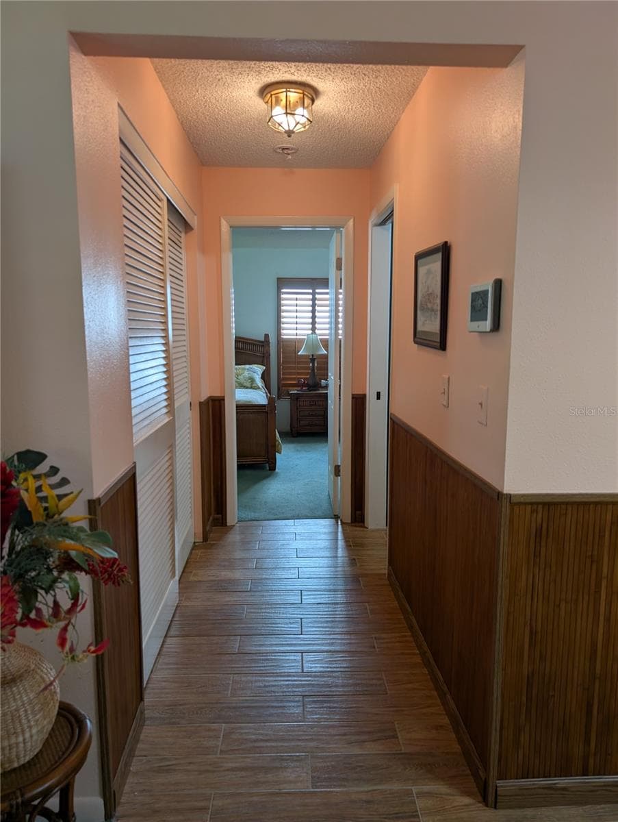 Hall closet on left, interior laundry with access to garage on right and primary bedroom straight ahead. Home is monitored by ADT security system on right wall. - 9204 36TH WAY N #6, PINELLAS PARK
