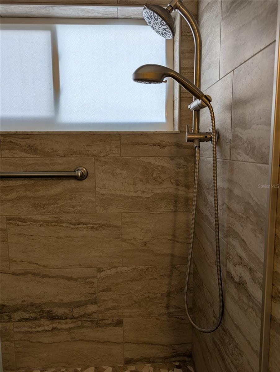 Other end of shower and close up view of tile which matches the flooring. - 9204 36TH WAY N #6, PINELLAS PARK