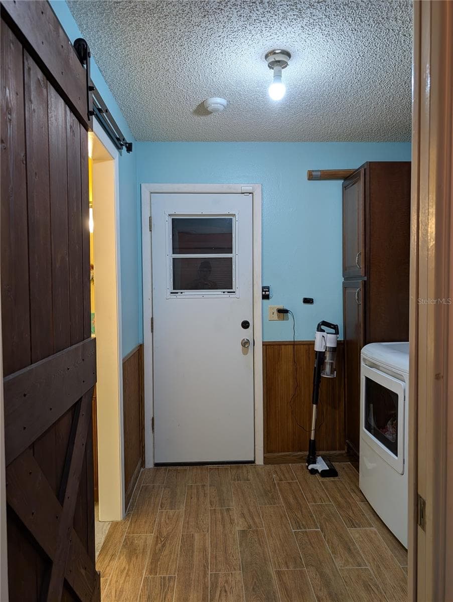 View from hallway to garage access door.  Barn door on left is to primary bathroom. - 9204 36TH WAY N #6, PINELLAS PARK