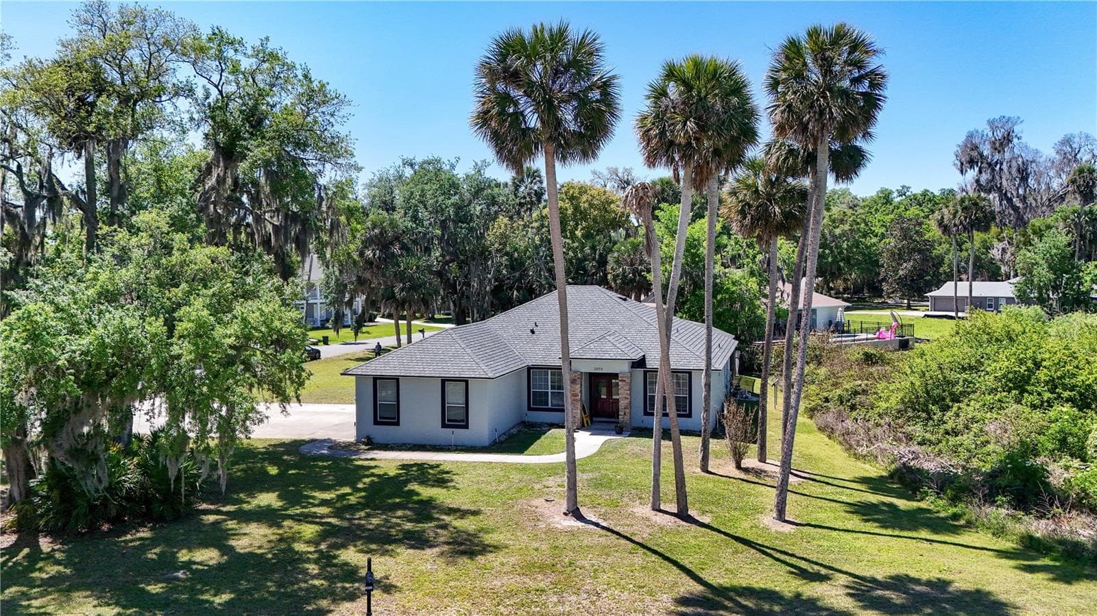 LOCATED ON A CORNER LOT ON A DEAD END STREET. LAKE BEAUCLAIRE VIEWS FROM THE FRONT OF HOME, LIVING ROOM AND DINING ROOM - 28931 BEAUCLAIRE DR, TAVARES