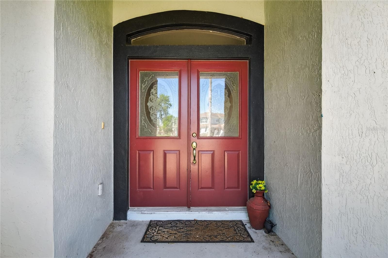 Double front door, featuring [Specific material, e.g., glass inserts, ornate carvings], leading to a welcoming entry. - 28931 BEAUCLAIRE DR, TAVARES