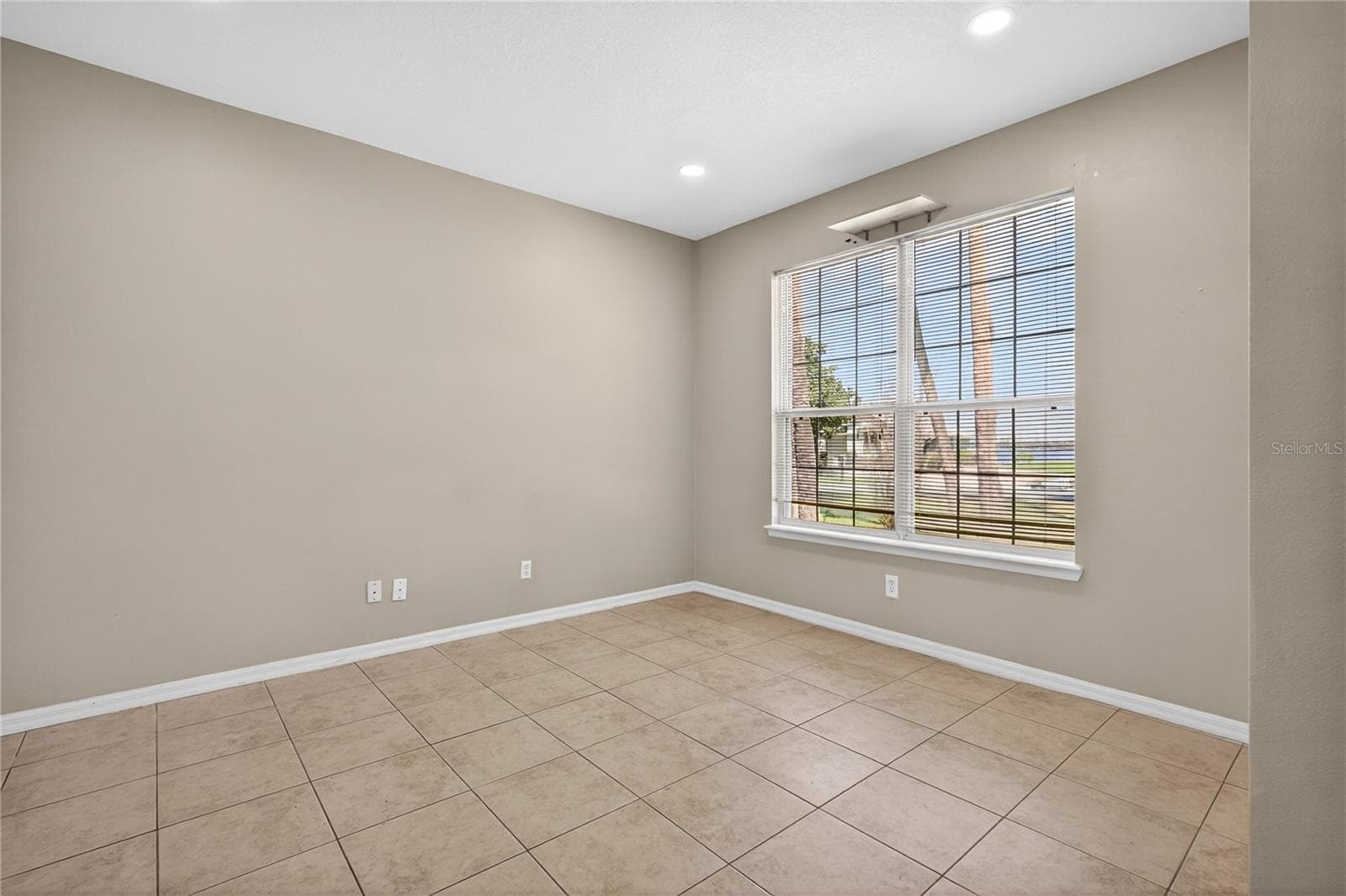 Formal living room boasts lake views. The large windows offer stunning water vistas, creating a bright and inviting space perfect for relaxation and entertaining. - 28931 BEAUCLAIRE DR, TAVARES
