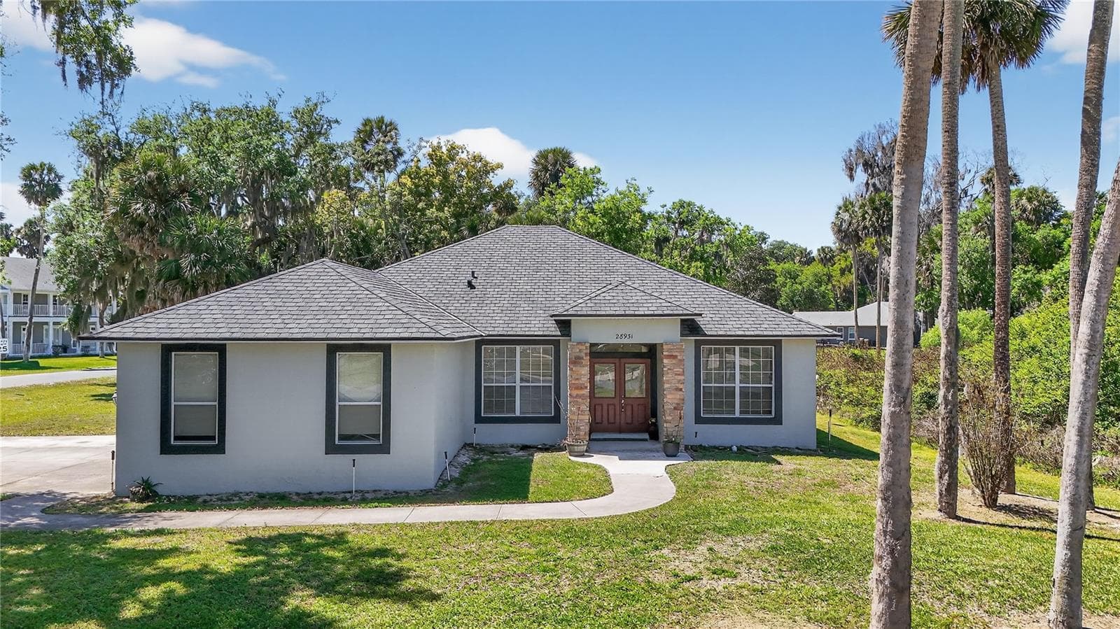 FRONT OF HOME FACES EAST AND HAS SIDE ENTRY GARAGE WITH EXTENDED DRIVEWAY WITH SUPPORTS 4 CARS ACROSS DRIVEWAY - 28931 BEAUCLAIRE DR, TAVARES
