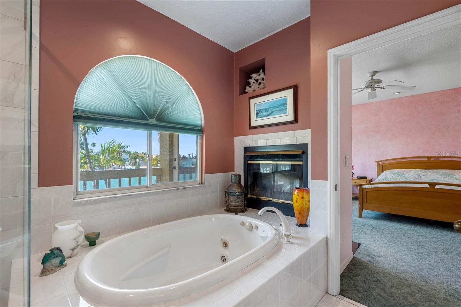 Primary bathroom with jetted tub and wood burning fireplace. - 11260 5TH ST E, TREASURE ISLAND