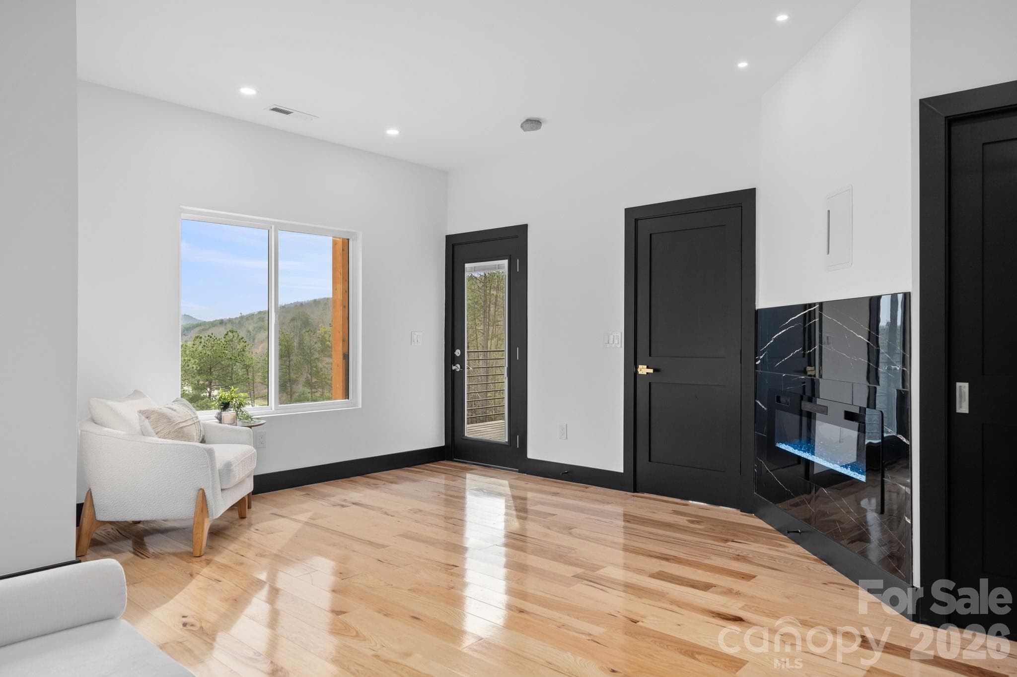 Primary bedroom seating area and electric fireplace - 74 Jeranna Road, Mills River