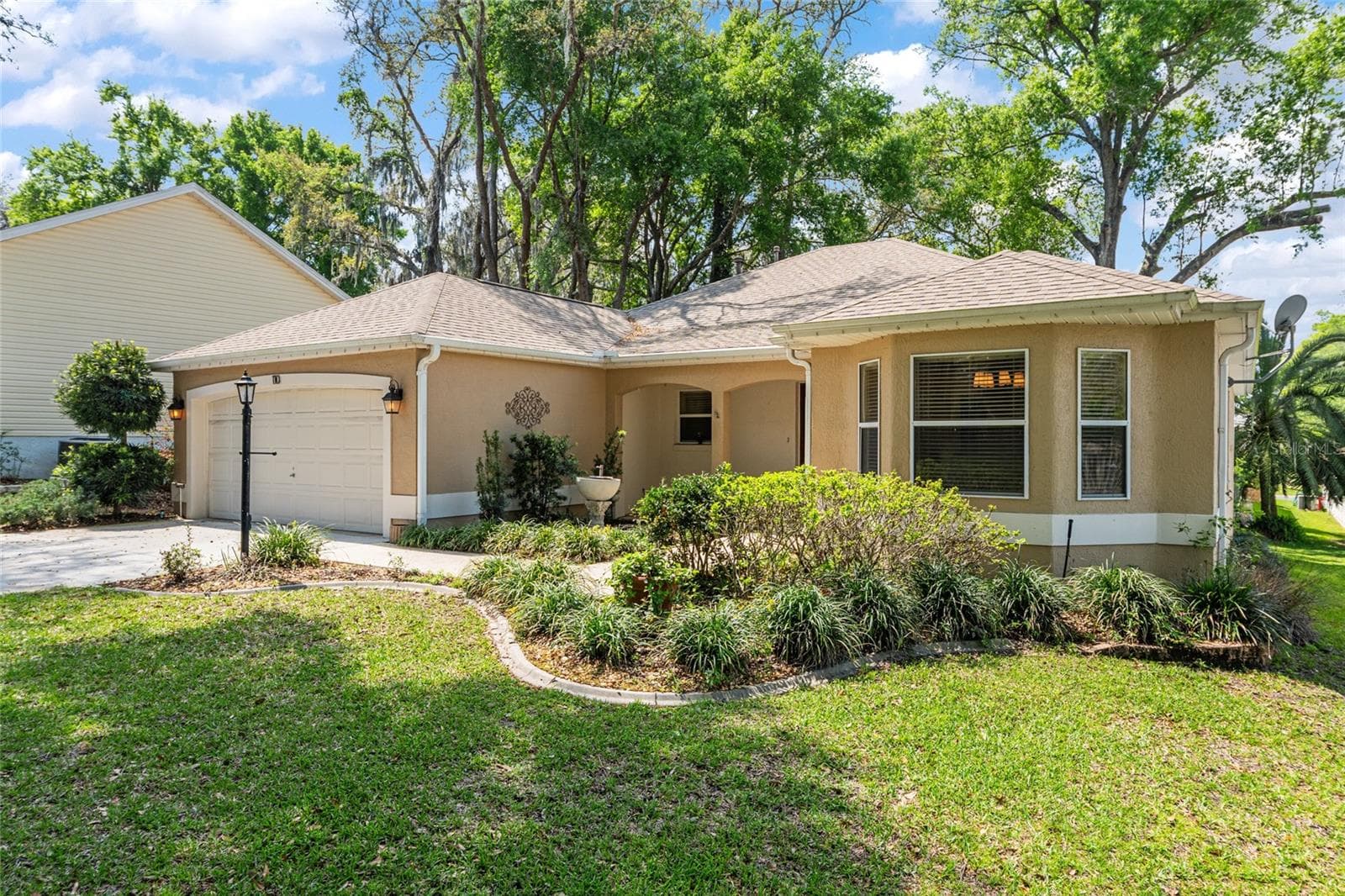Front Exterior: Charming single-story home with a welcoming façade, mature trees, and well-maintained landscaping that enhances curb appeal. - 110 CHULA VISTA AVE, LADY LAKE