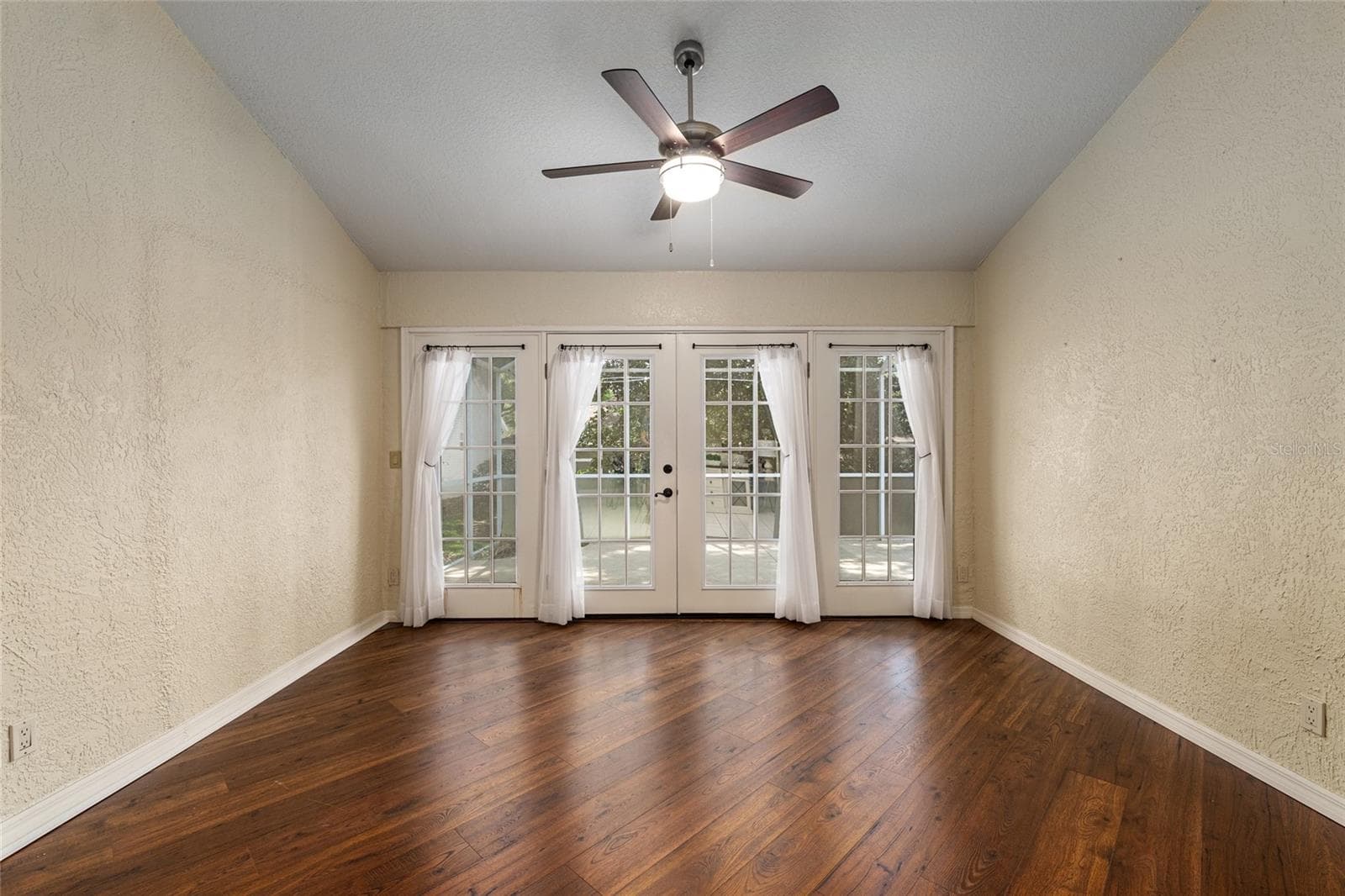 Rear Room / Flex Space: Light-filled room with French doors provides access to outdoor space and versatile use options.Copy AllFront Exterior: Charming single-story home with a welcoming façade, mature trees, and well-maintained landscaping that enhances curb appeal.Front Exterior & Driveway: Spacious driveway and two-car garage complement the home’s clean lines and inviting covered entry.Front Exterior (Twilight): Evening view highlights exterior lighting and a warm, inviting entrance framed by lush greenery.Front Entry & Walkway: Covered front entry with decorative accents and a landscaped walkway creates a pleasant approach to the home.Foyer Entry: Bright foyer features tile flooring, neutral tones, and decorative glass front door panels for added natural light.Foyer Reverse View: Entry hallway showcases high ceilings, classic wainscoting detail, and an open flow into the main living areas.Living Room: Comfortable living area with tile flooring, ceiling fan, and a fireplace that s - 110 CHULA VISTA AVE, LADY LAKE