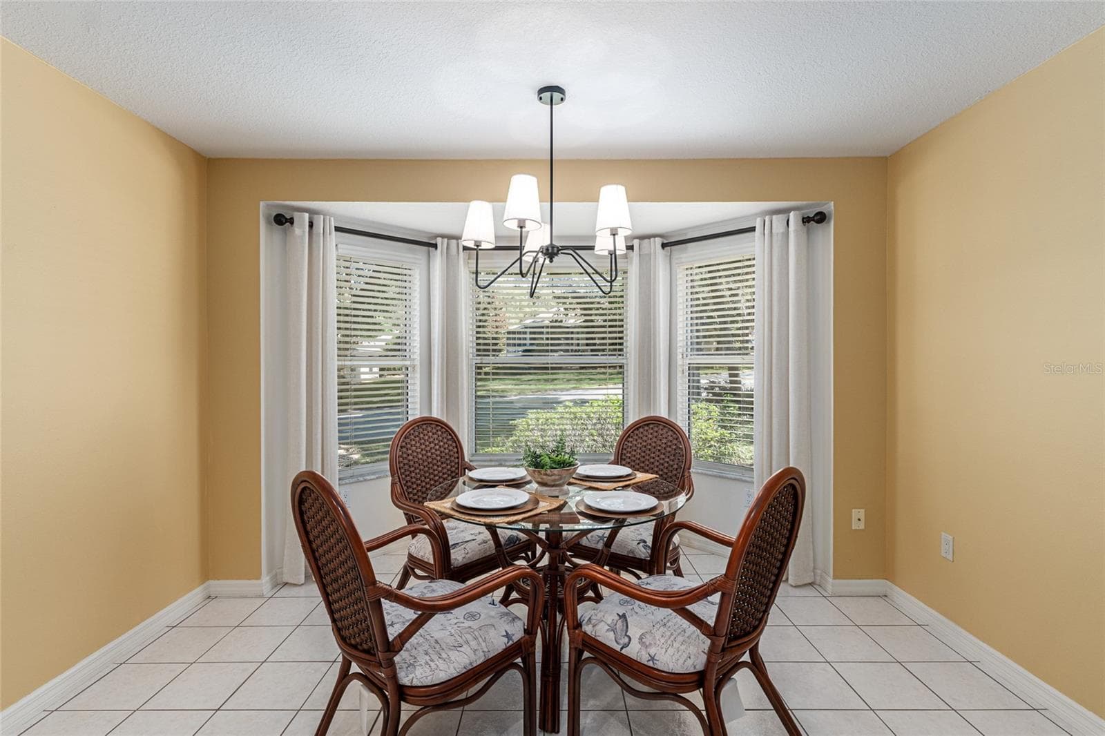 Breakfast Nook: Bright breakfast nook with bay-style windows and a modern light fixture creates an inviting space for casual dining. - 110 CHULA VISTA AVE, LADY LAKE