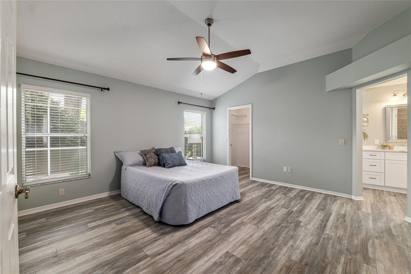 Primary Bedroom: Spacious primary bedroom features vaulted ceilings, neutral tones, and updated flooring for a comfortable retreat. - 110 CHULA VISTA AVE, LADY LAKE