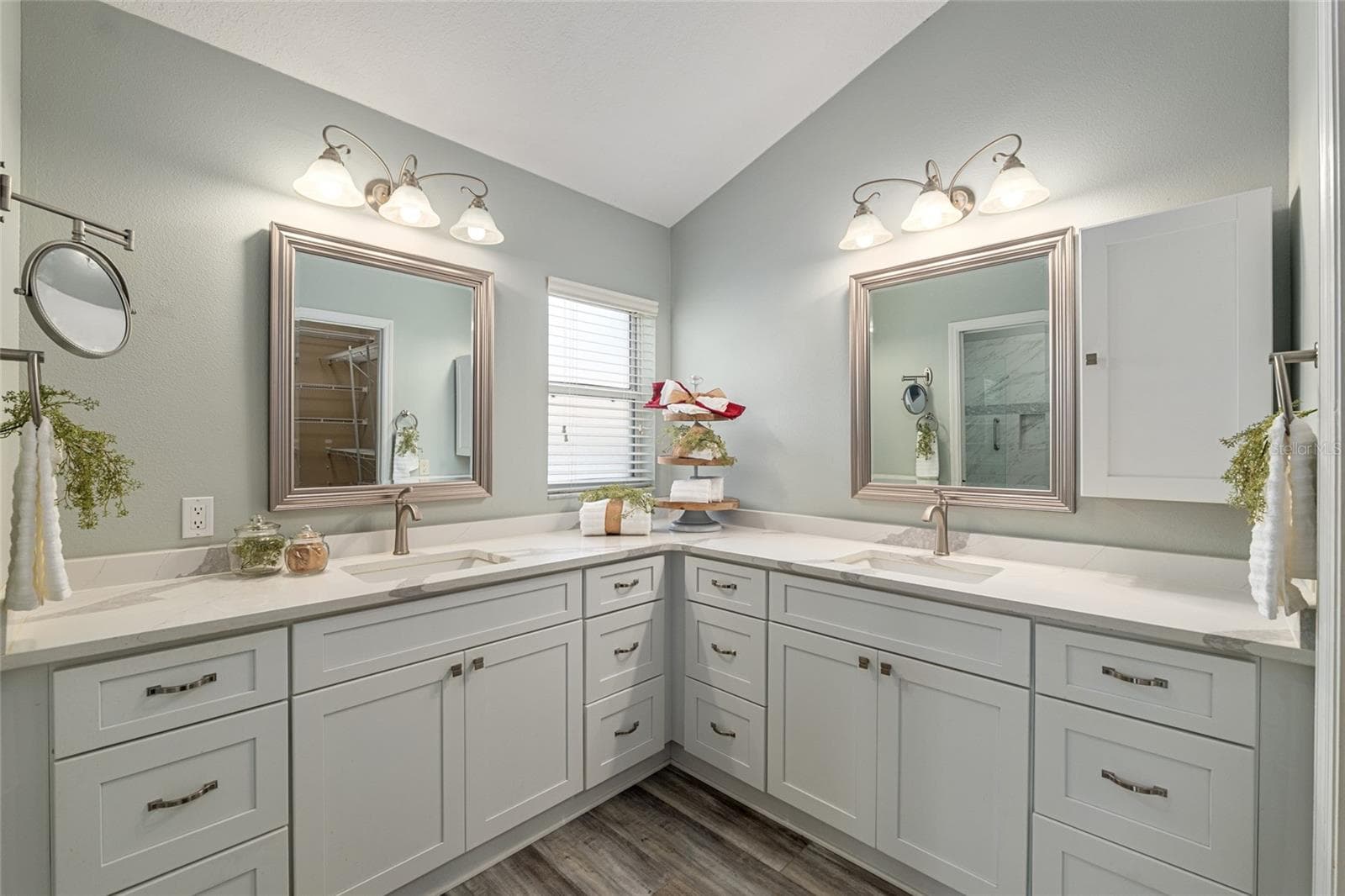 Primary Bathroom Vanity: Dual-sink vanity with ample cabinetry, large mirrors, and updated finishes provides both style and functionality. - 110 CHULA VISTA AVE, LADY LAKE