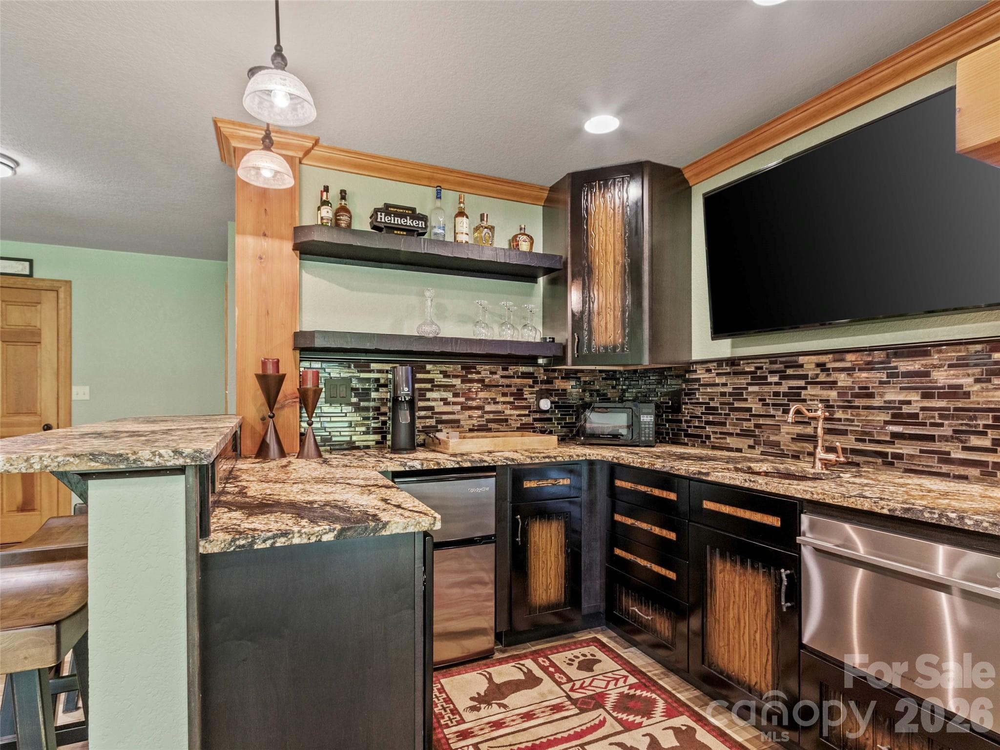 Stylish lower-level bar with Custom built cabinets, leathered countertops, beverage fridge, & Fisher & Paykel dishwasher. Entertainment at its finest - 151 Austin Mountain Drive, Burnsville