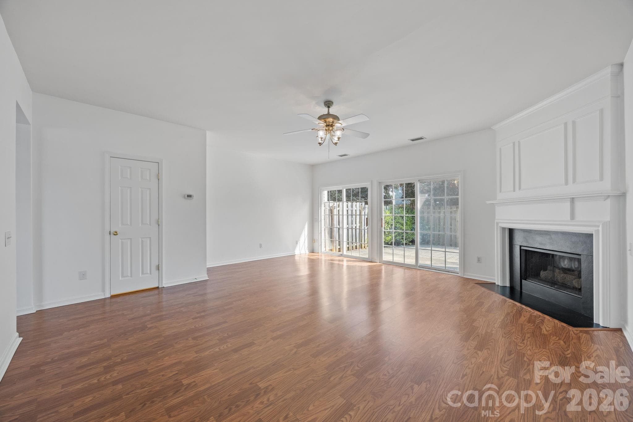View of dining area and living room with doors leading to large rear patio. - Charlotte