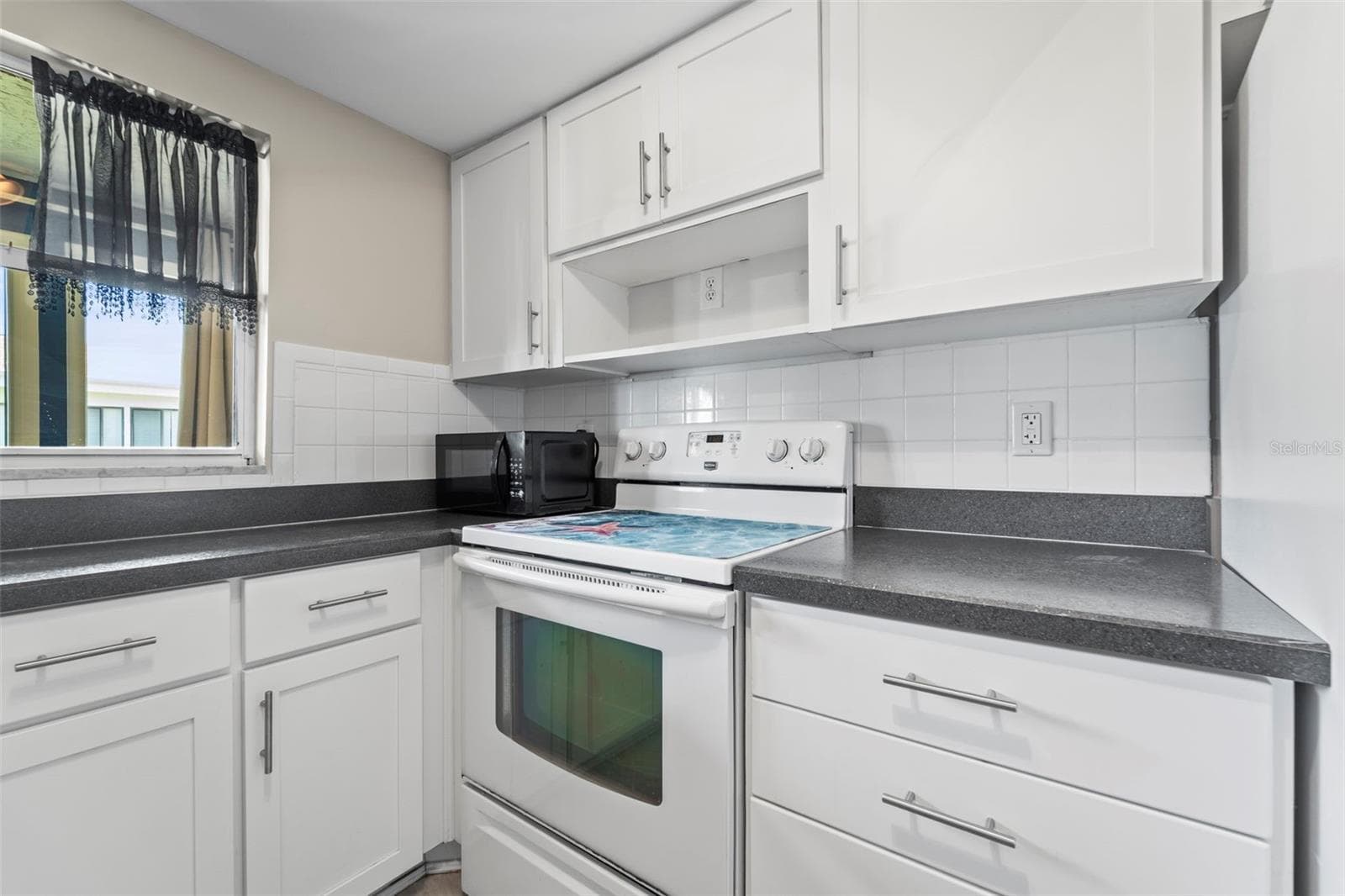 Kitchen window opens to the back porch area - 1 WINDRUSH BLVD #24, INDIAN ROCKS BEACH