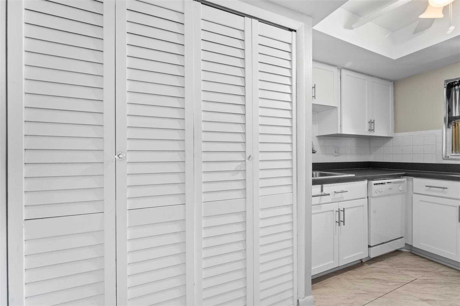 Kitchen area with the closet doors covering the storage area and the washer and dryer - 1 WINDRUSH BLVD #24, INDIAN ROCKS BEACH