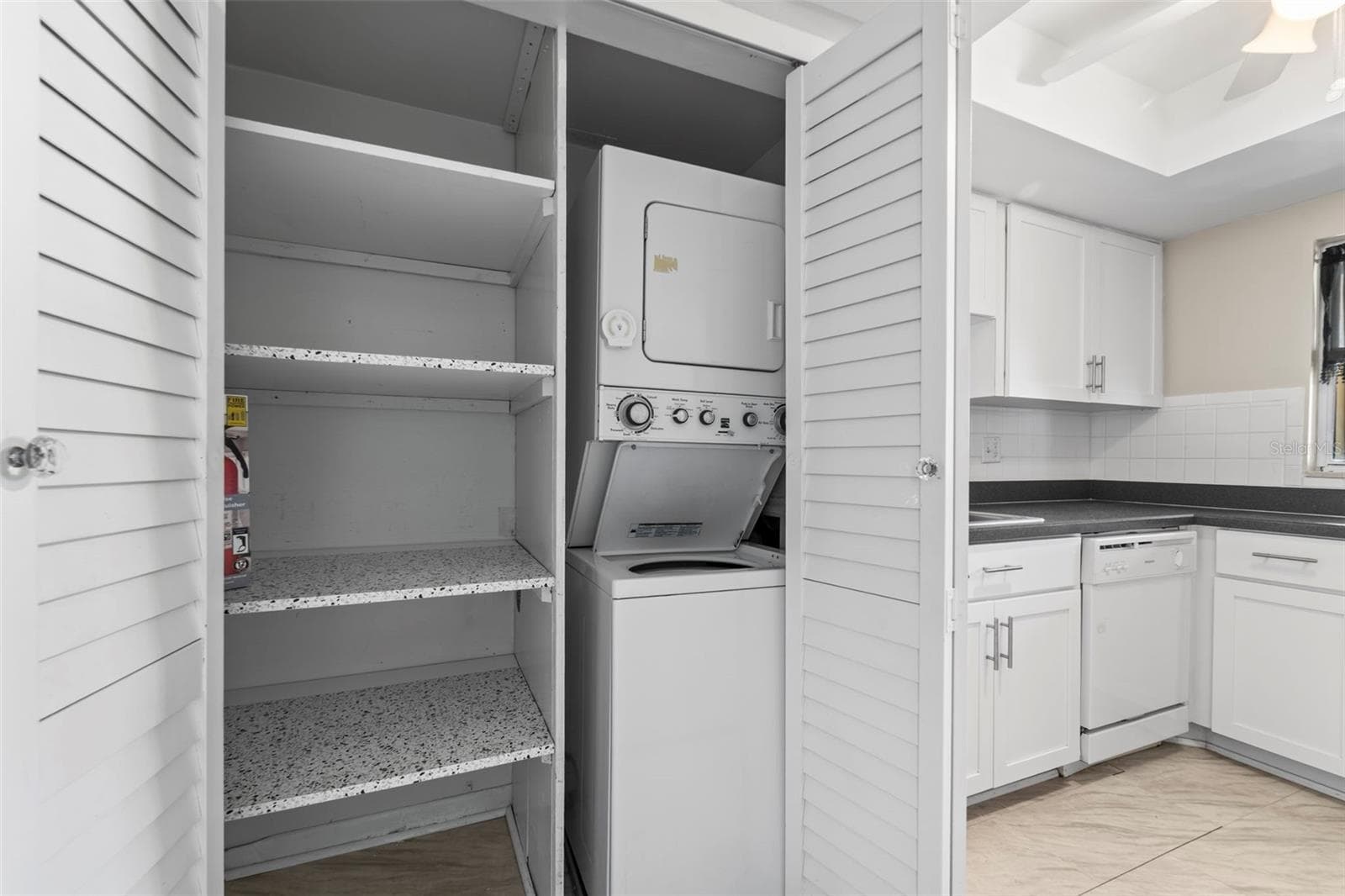 Kitchen storage and a view of the stackable washer and dryer - 1 WINDRUSH BLVD #24, INDIAN ROCKS BEACH