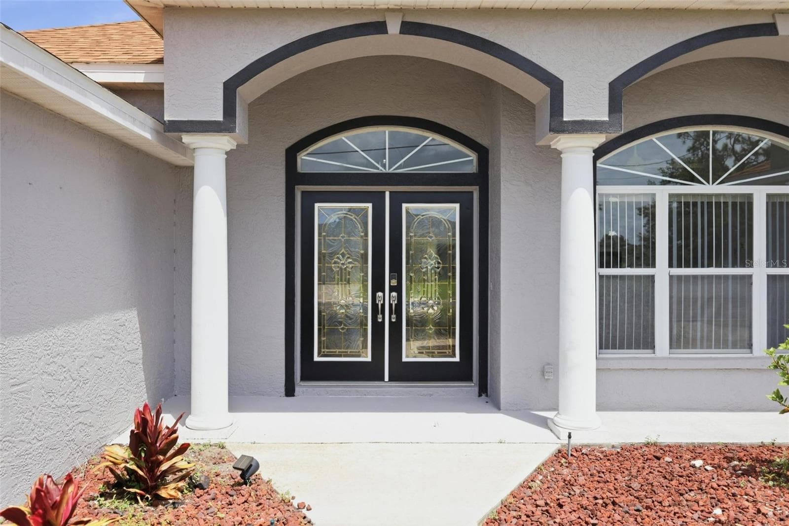 Grand arched double-door entry with decorative glass and covered front porch - 605 ROTONDA CIR, ROTONDA WEST