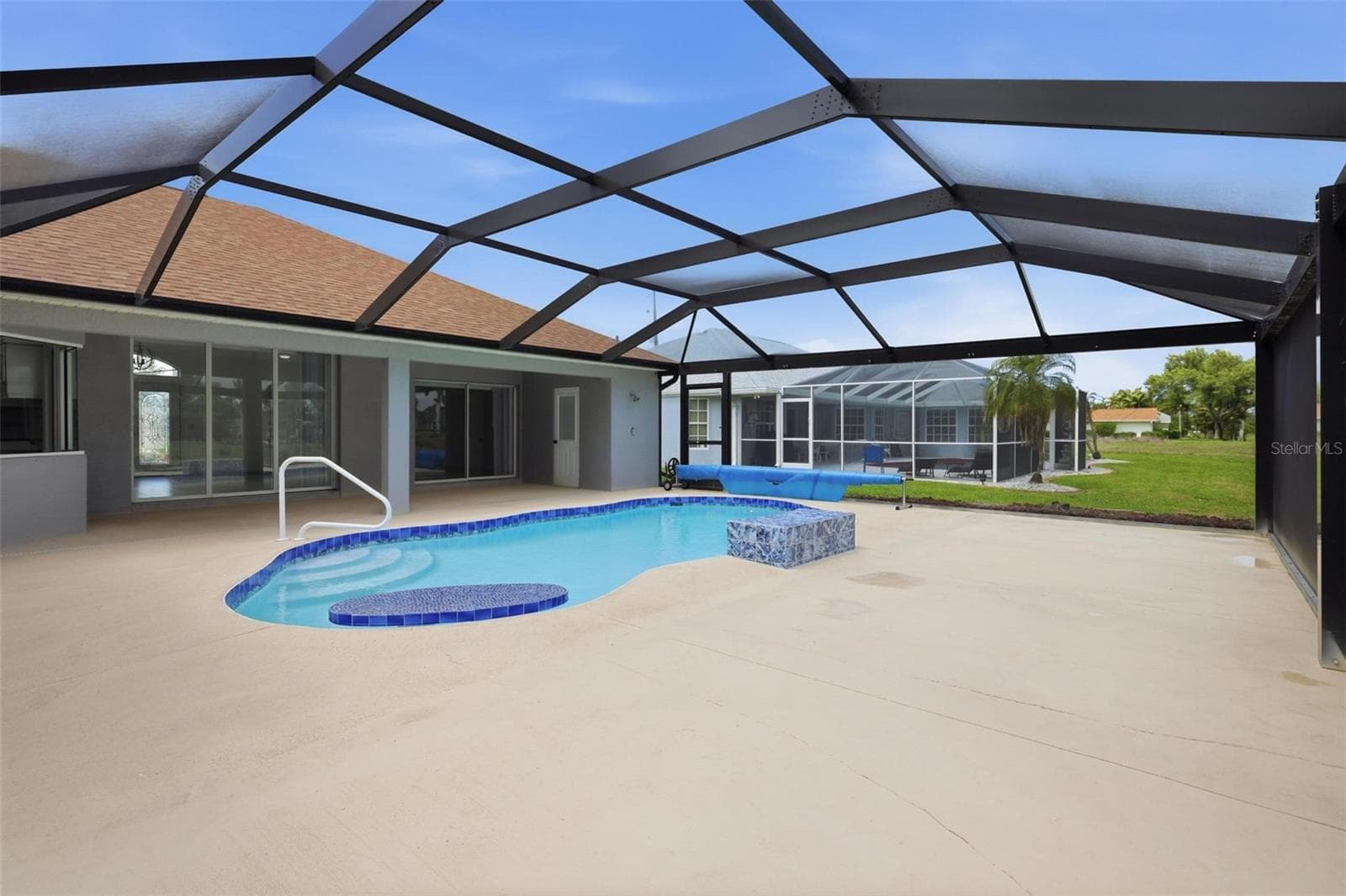 Generous pool deck with panoramic screen enclosure and peaceful backyard setting - 605 ROTONDA CIR, ROTONDA WEST