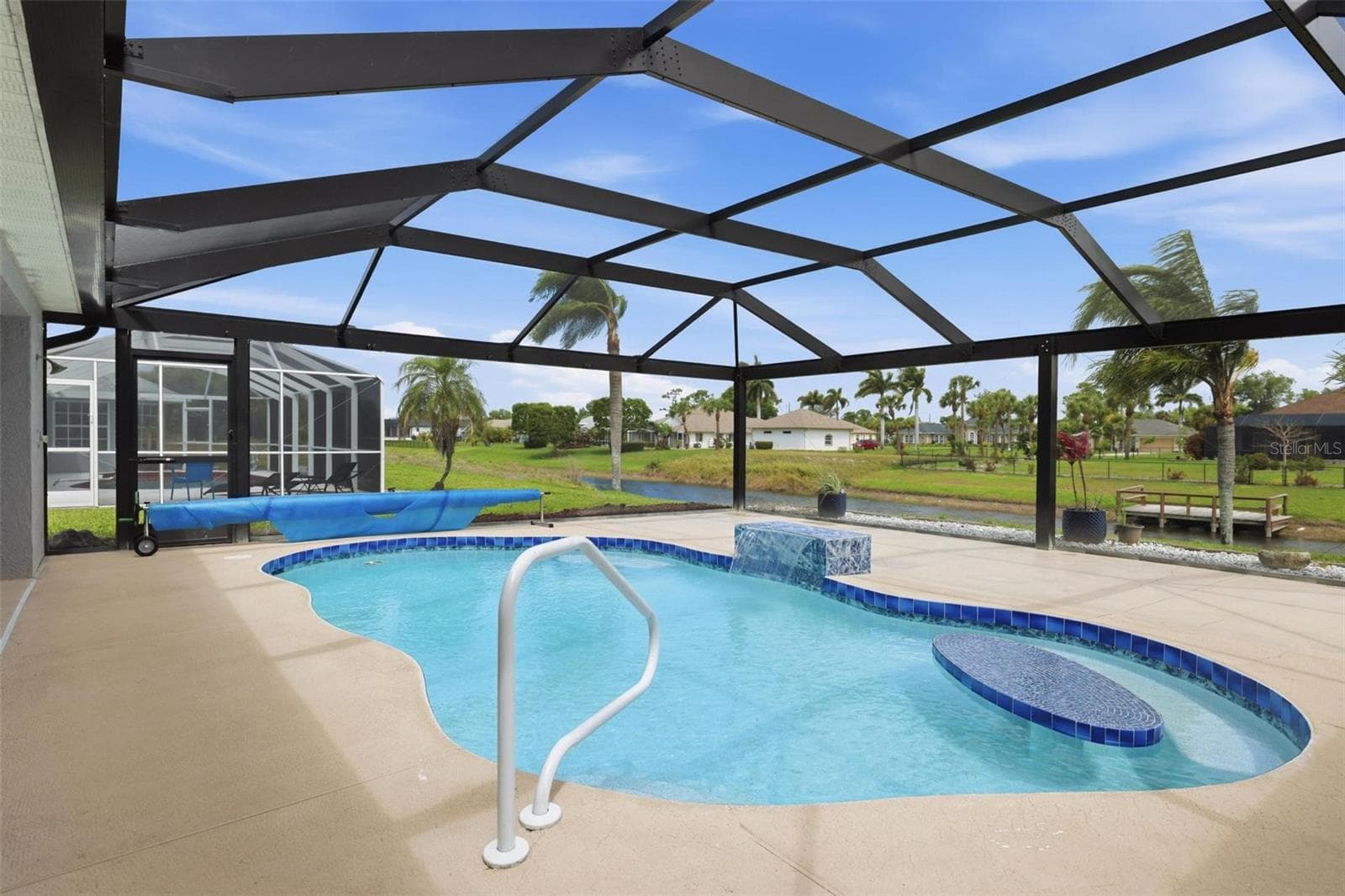 Spacious screened lanai showcasing newly redone pool and open surrounding views - 605 ROTONDA CIR, ROTONDA WEST