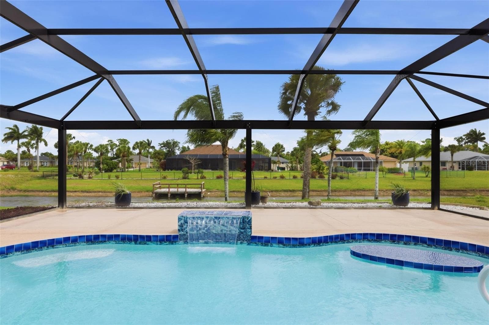Bright pool interior with panoramic screen enclosure offering seamless indoor-outdoor living - 605 ROTONDA CIR, ROTONDA WEST