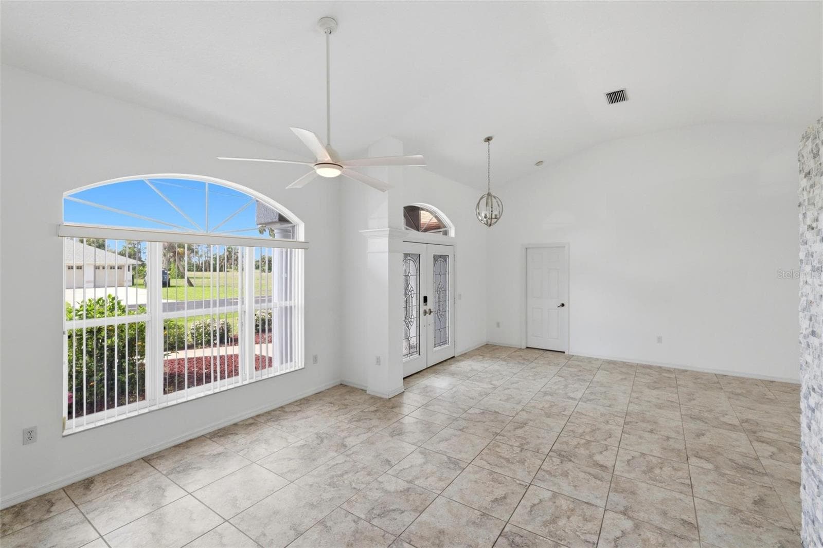 Bright foyer or bonus room with arched window and elegant tiled flooring - 605 ROTONDA CIR, ROTONDA WEST