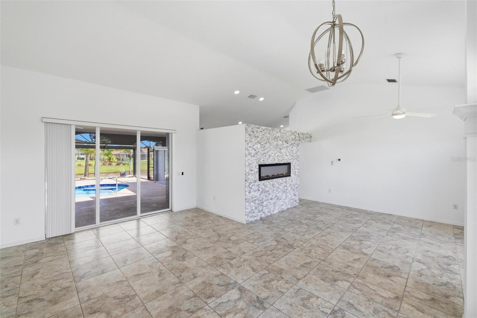Spacious living area with chandelier, large windows, and light-filled neutral interior - 605 ROTONDA CIR, ROTONDA WEST