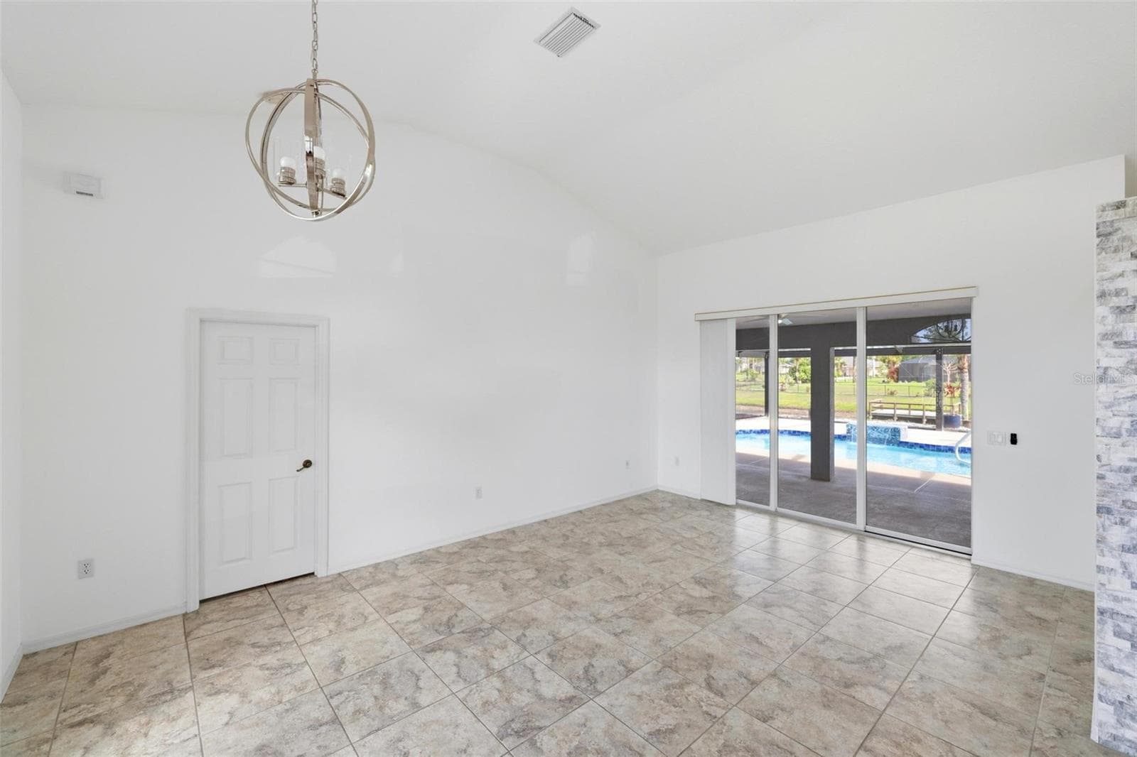 Bright open room with large windows, tile floors, and move-in ready condition - 605 ROTONDA CIR, ROTONDA WEST