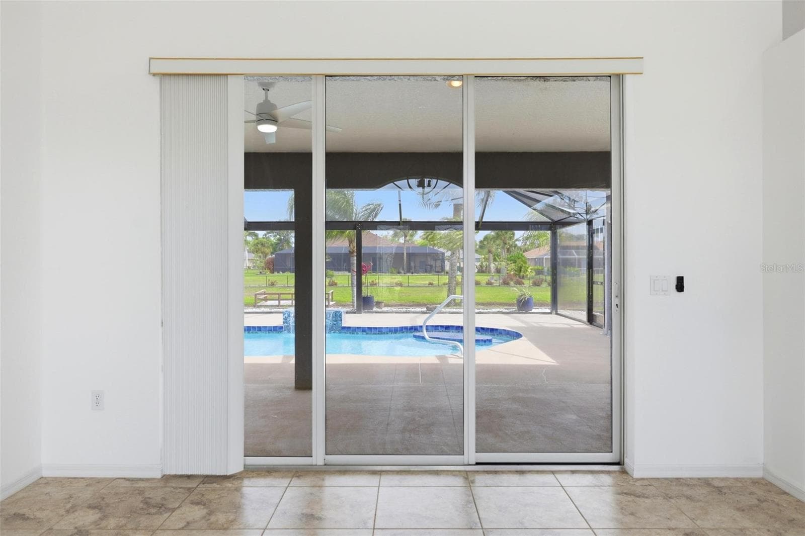 Bright living area with sliding glass doors overlooking the extended screened lanai - 605 ROTONDA CIR, ROTONDA WEST