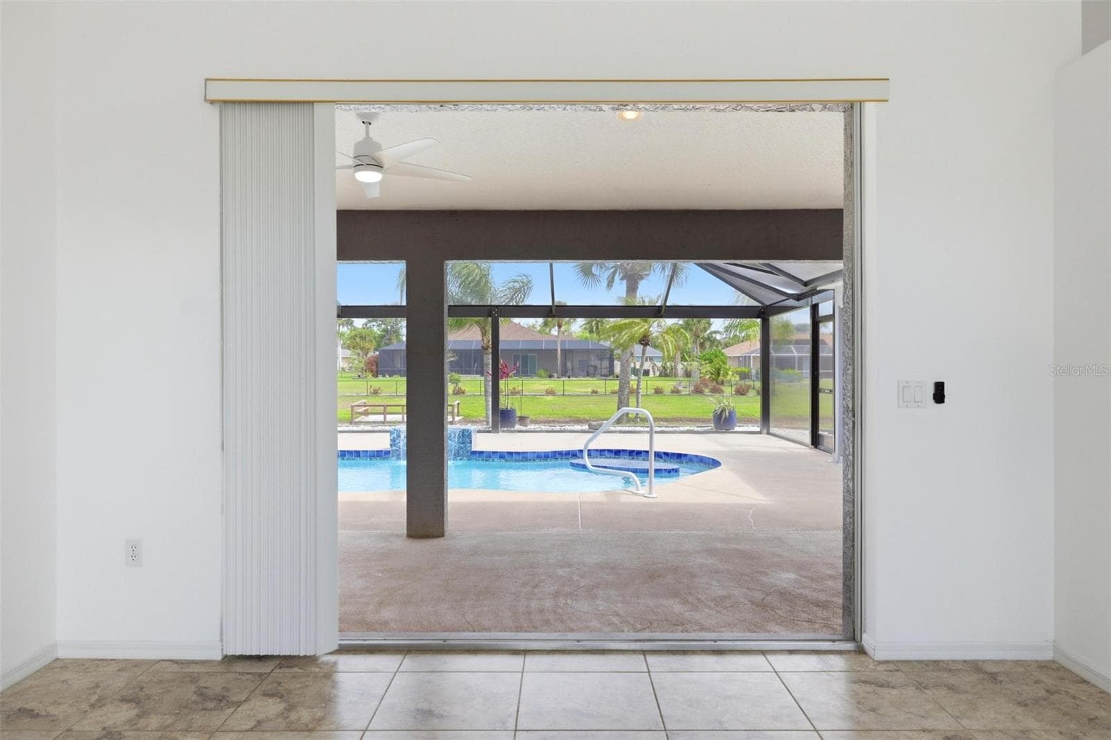 Sliding glass doors leading to extended screened lanai and newly redone 2025 pool - 605 ROTONDA CIR, ROTONDA WEST