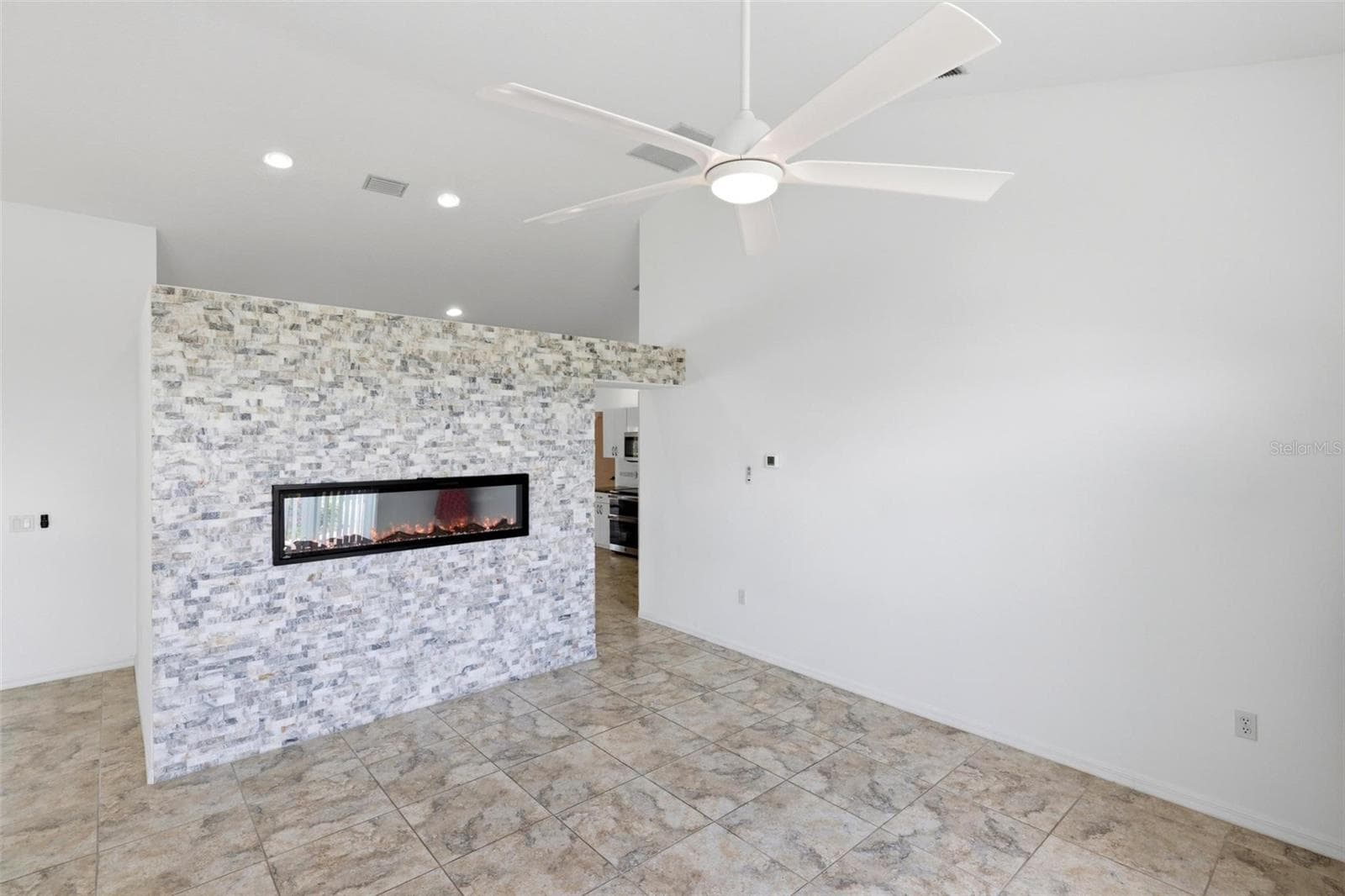 Cozy room with decorative accent wall, ceiling fan, and comfortable neutral finishes - 605 ROTONDA CIR, ROTONDA WEST