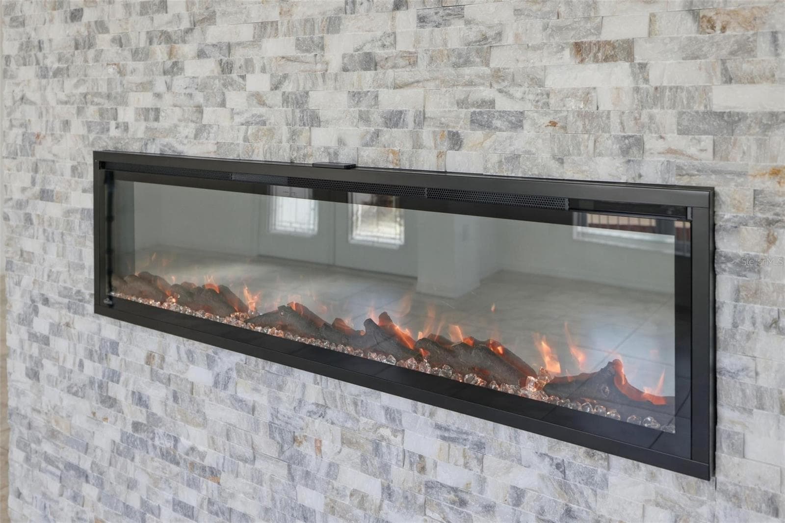Stunning floor-to-ceiling linear fireplace with stone surround as a dramatic focal point - 605 ROTONDA CIR, ROTONDA WEST