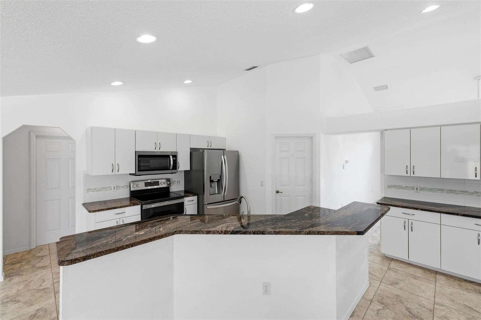 Bright kitchen with white cabinetry, new 2024 appliances, and move-in ready condition - 605 ROTONDA CIR, ROTONDA WEST