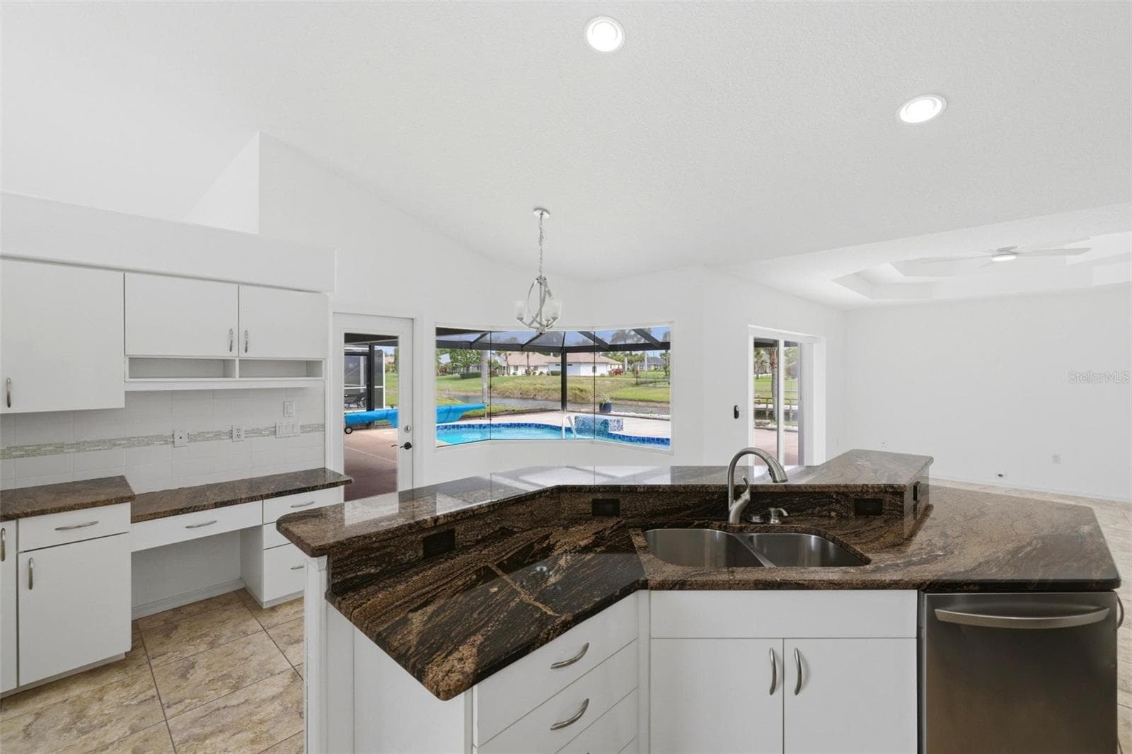 Open kitchen with large island, new 2024 stainless appliances, and ample counter space - 605 ROTONDA CIR, ROTONDA WEST