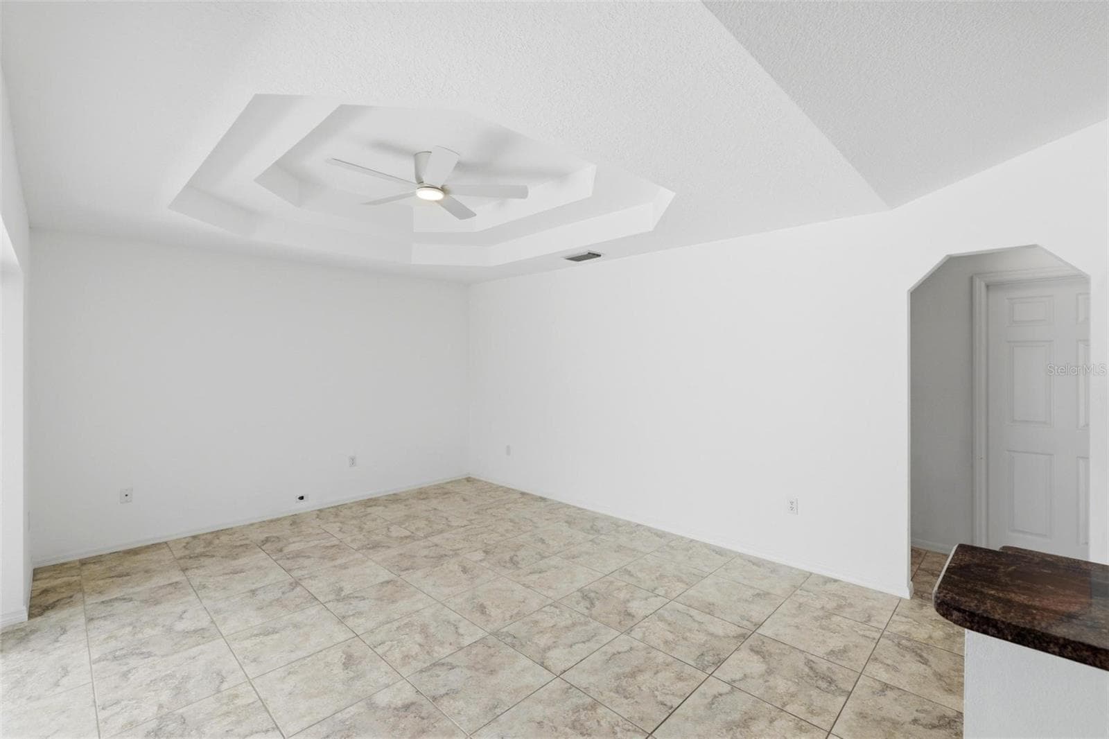 Open living and sitting area adjacent to kitchen with neutral tile floors and abundant natural light - 605 ROTONDA CIR, ROTONDA WEST