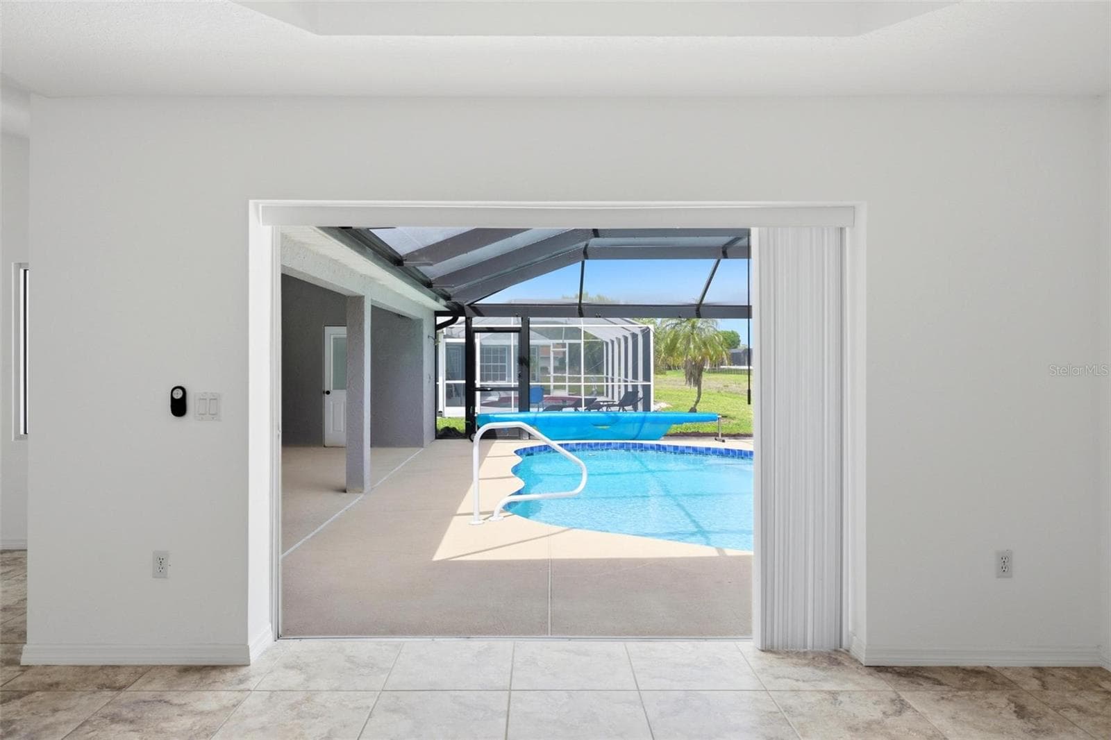 Sun-filled room with large windows offering relaxing views of the pool area - 605 ROTONDA CIR, ROTONDA WEST