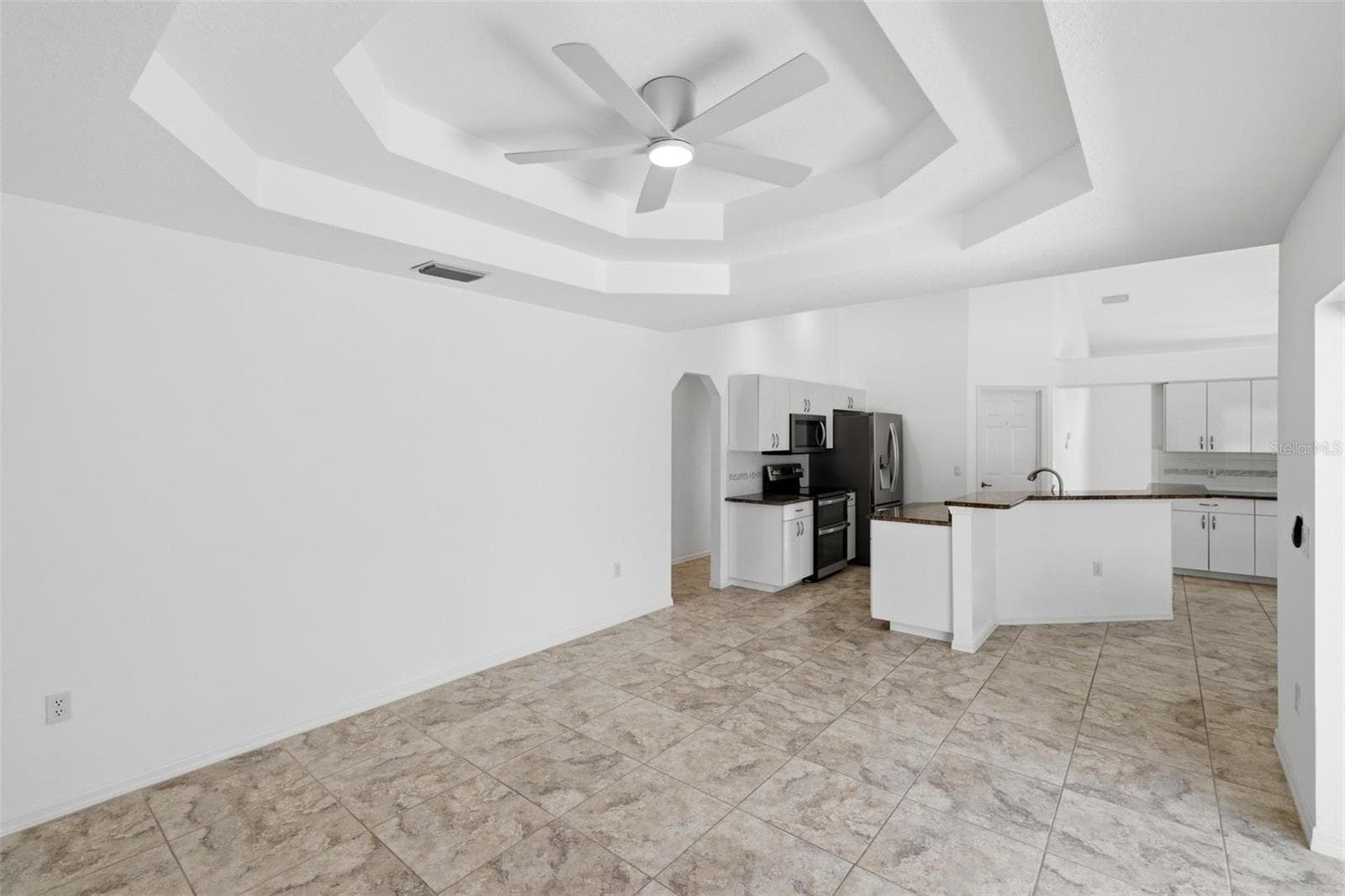 Open-concept kitchen and living area with coffered ceiling and modern finishes - 605 ROTONDA CIR, ROTONDA WEST
