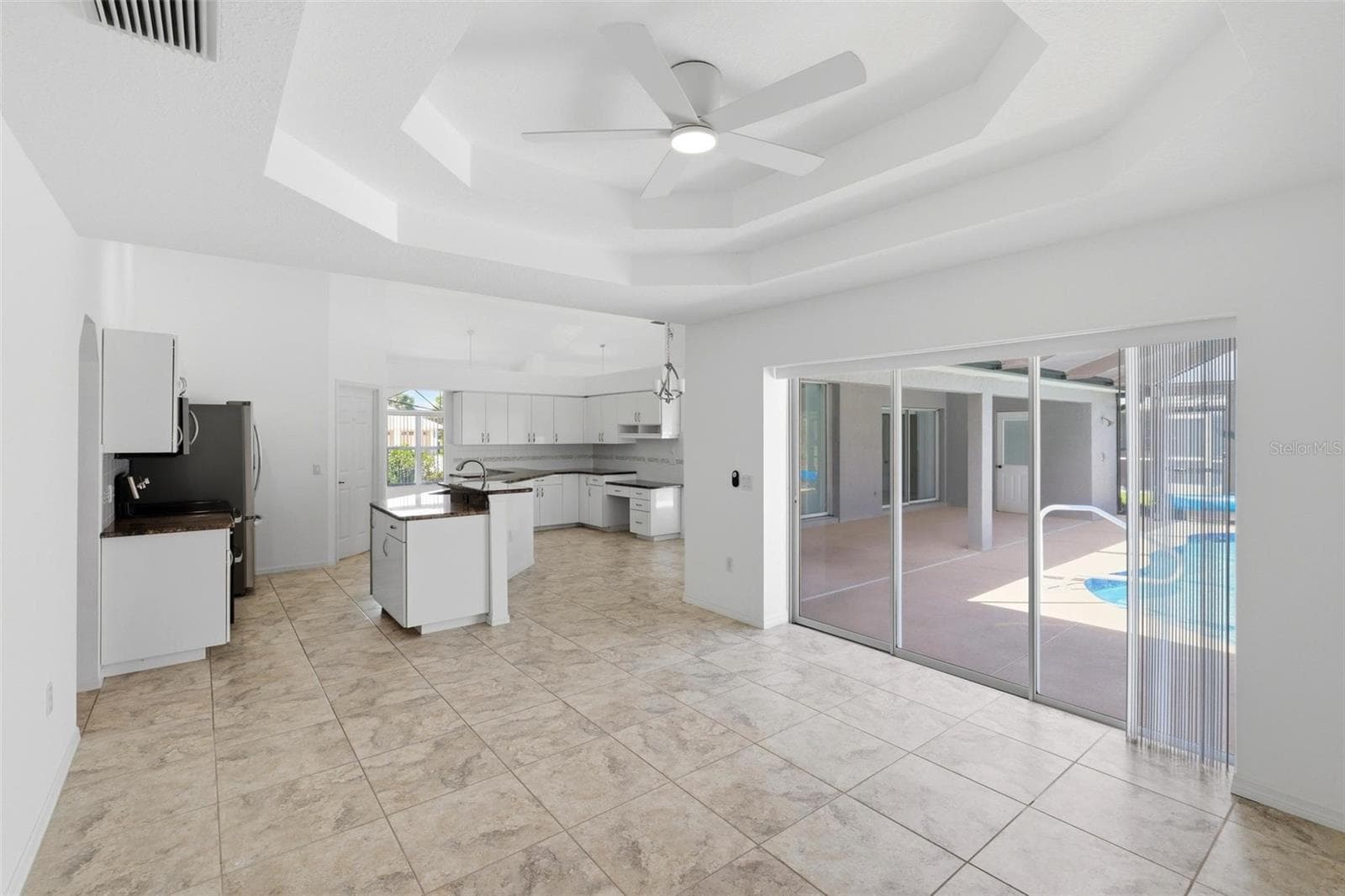 Gourmet kitchen with all-new 2024 stainless appliances and views to pool beyond - 605 ROTONDA CIR, ROTONDA WEST