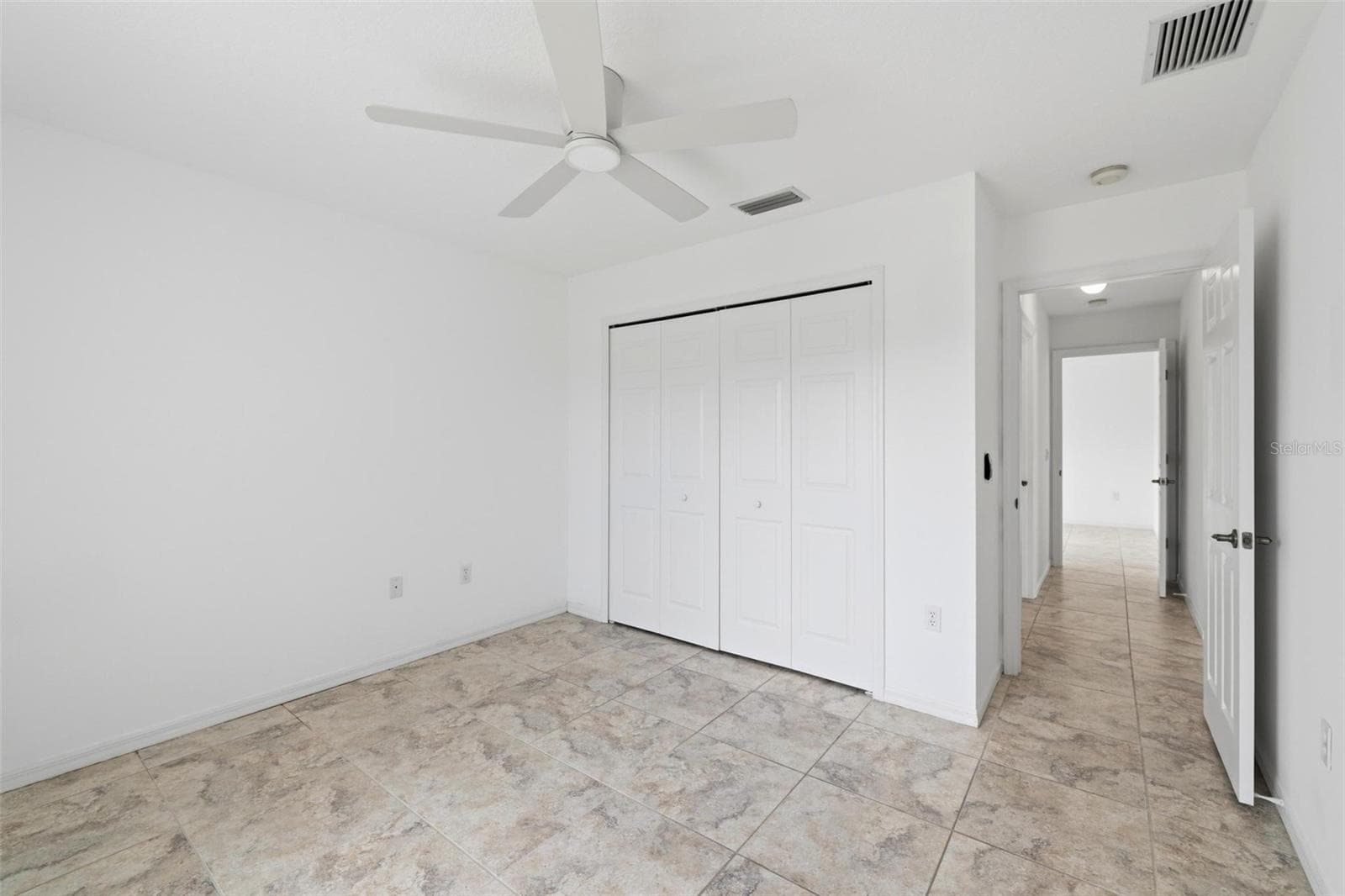 Comfortable bedroom with ceiling fan, neutral walls, and tile flooring throughout - 605 ROTONDA CIR, ROTONDA WEST