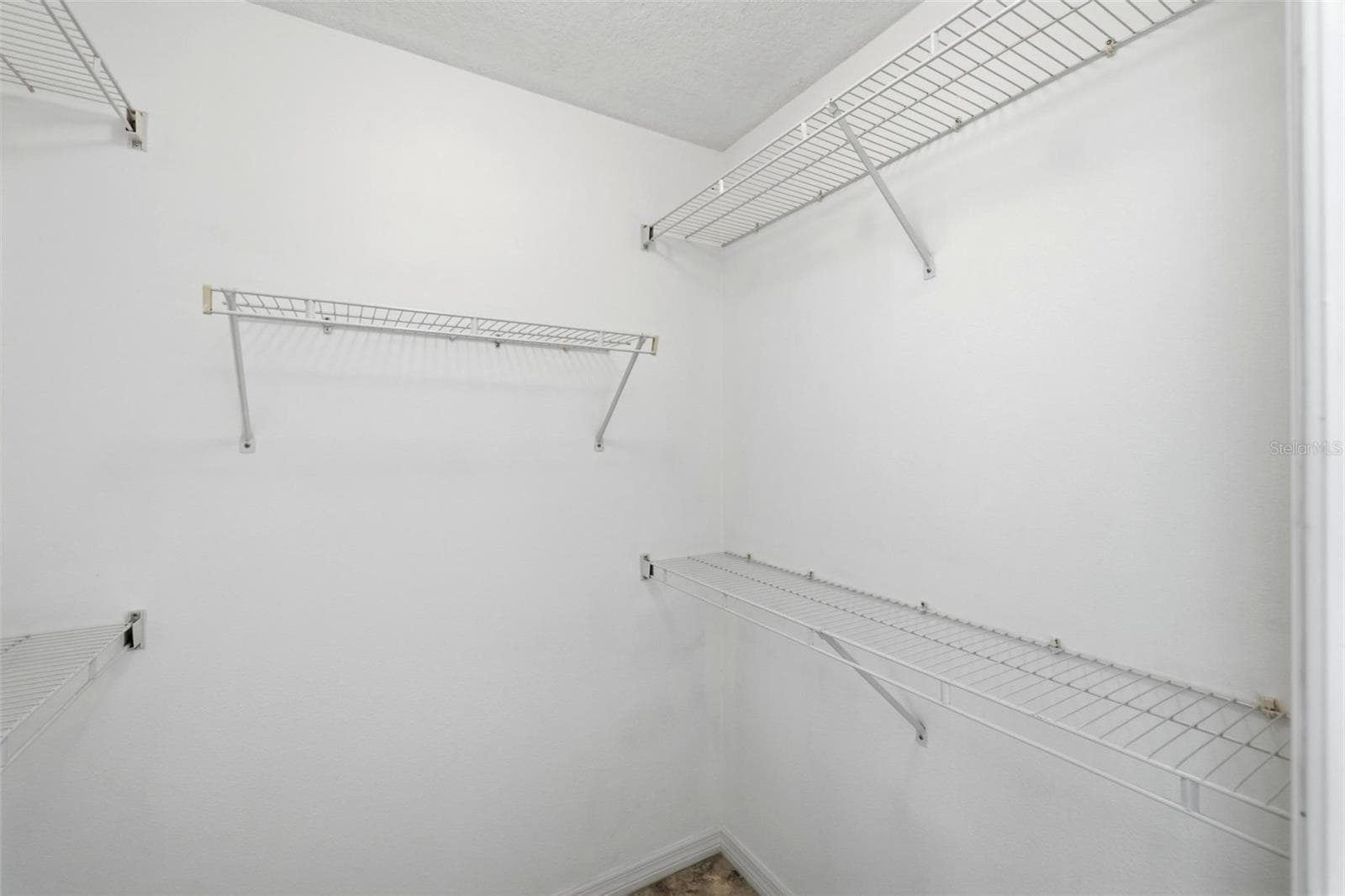 Spacious walk-in closet with ample shelving and plenty of organized storage space - 605 ROTONDA CIR, ROTONDA WEST