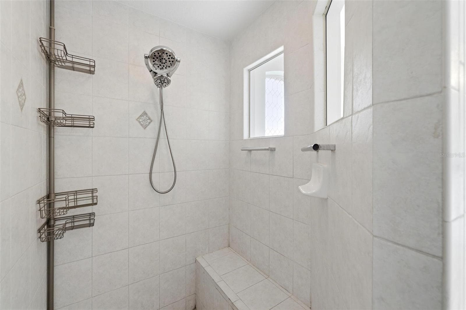 Walk-in shower with glass enclosure, tile surround, and updated modern fixtures - 605 ROTONDA CIR, ROTONDA WEST